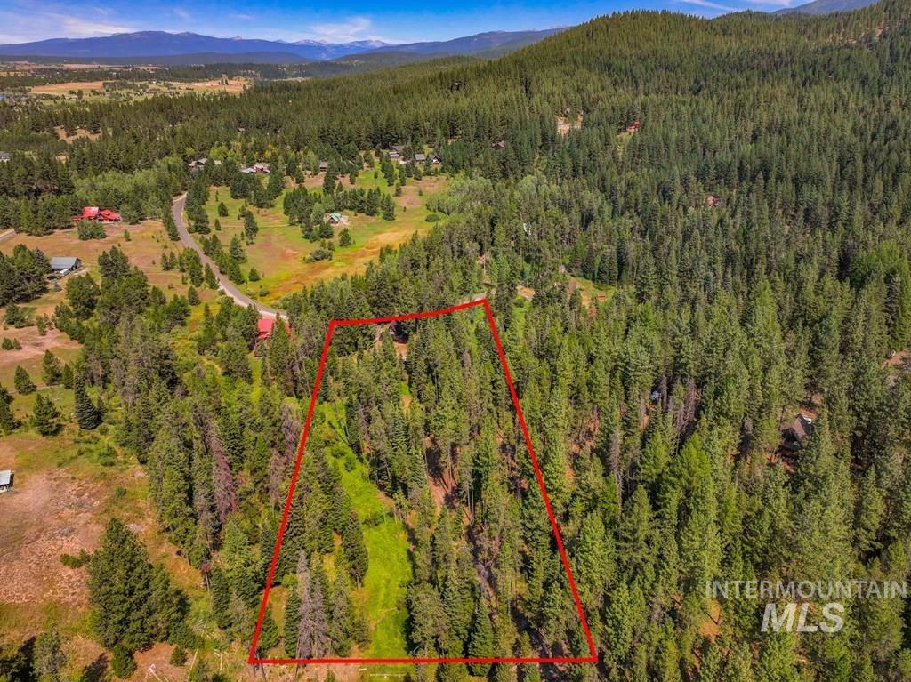 Aerial overview of property's location with property parcel outlined and a mountain backdrop