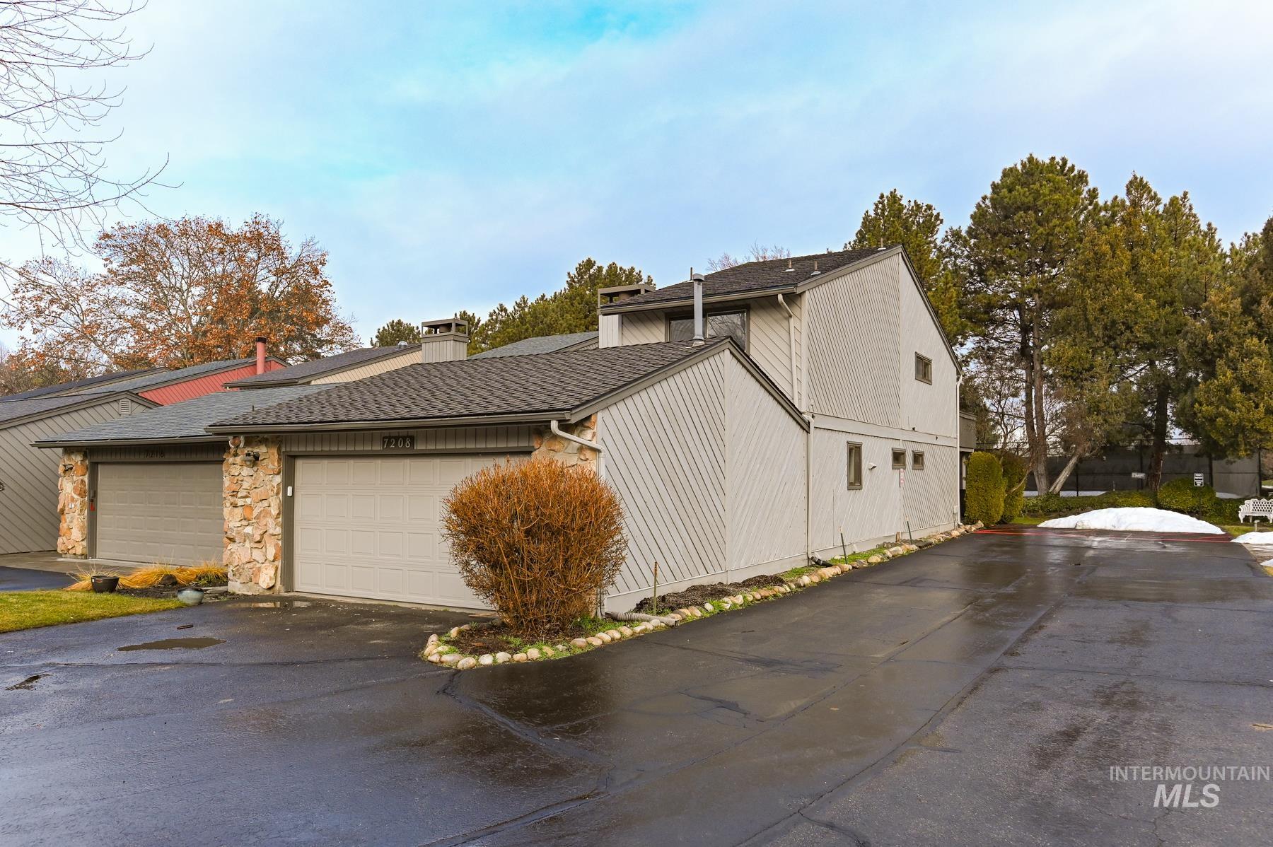 View of side of home featuring a chimney, roof with shingles, and stone siding