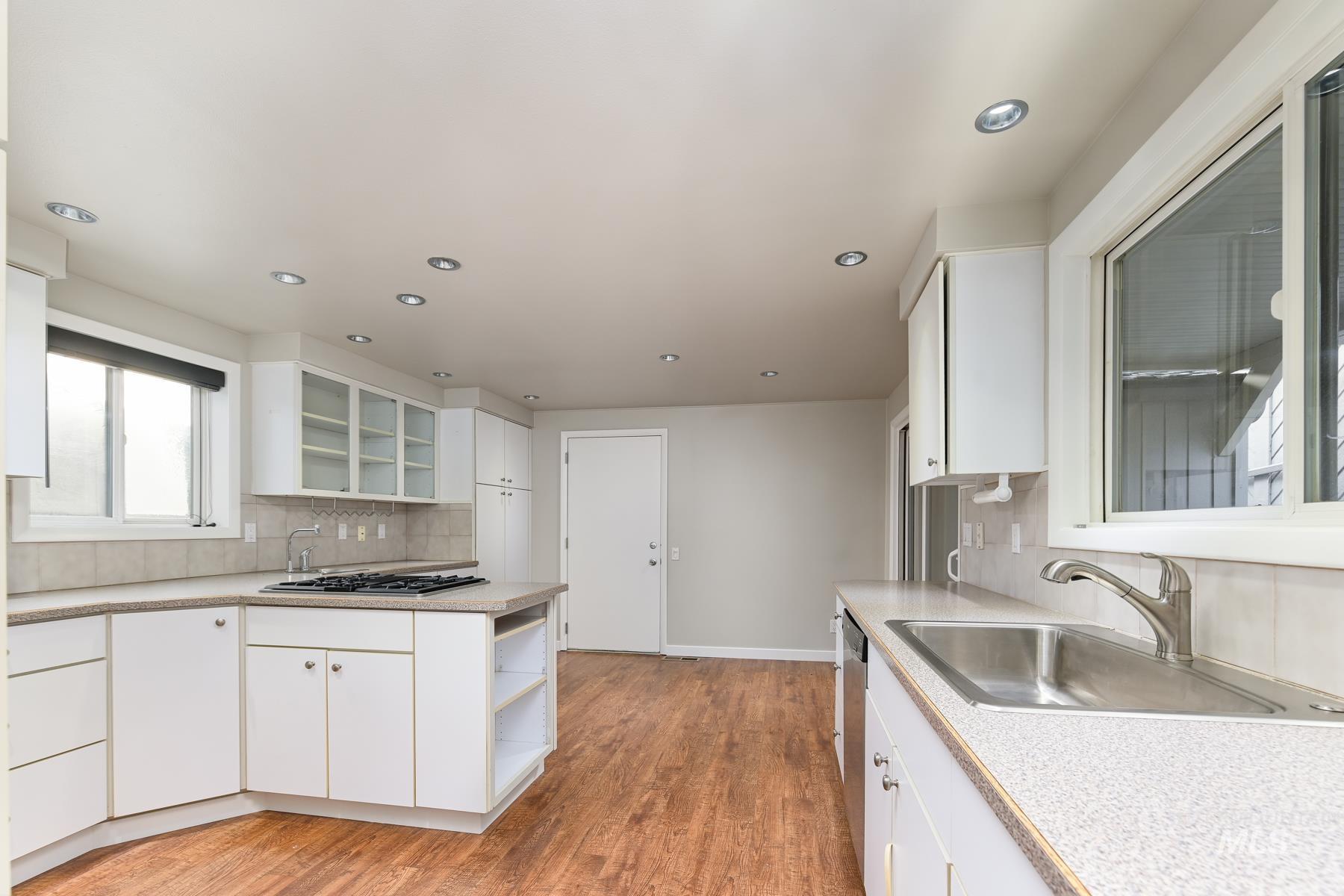 Kitchen featuring white cabinetry, light countertops, open shelves, glass fronted cabinets, and recessed lighting