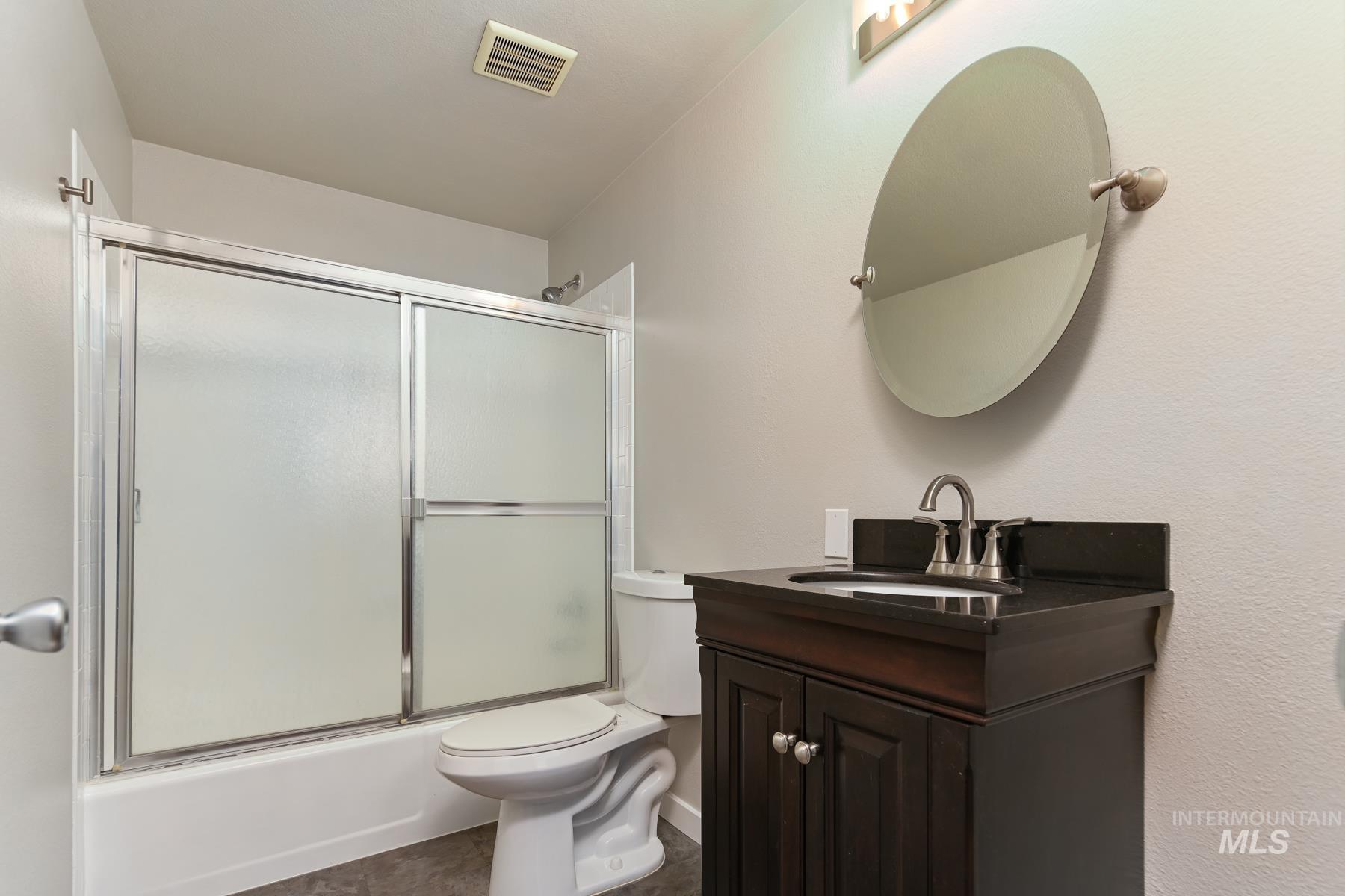 Full bathroom featuring vanity and enclosed tub / shower combo