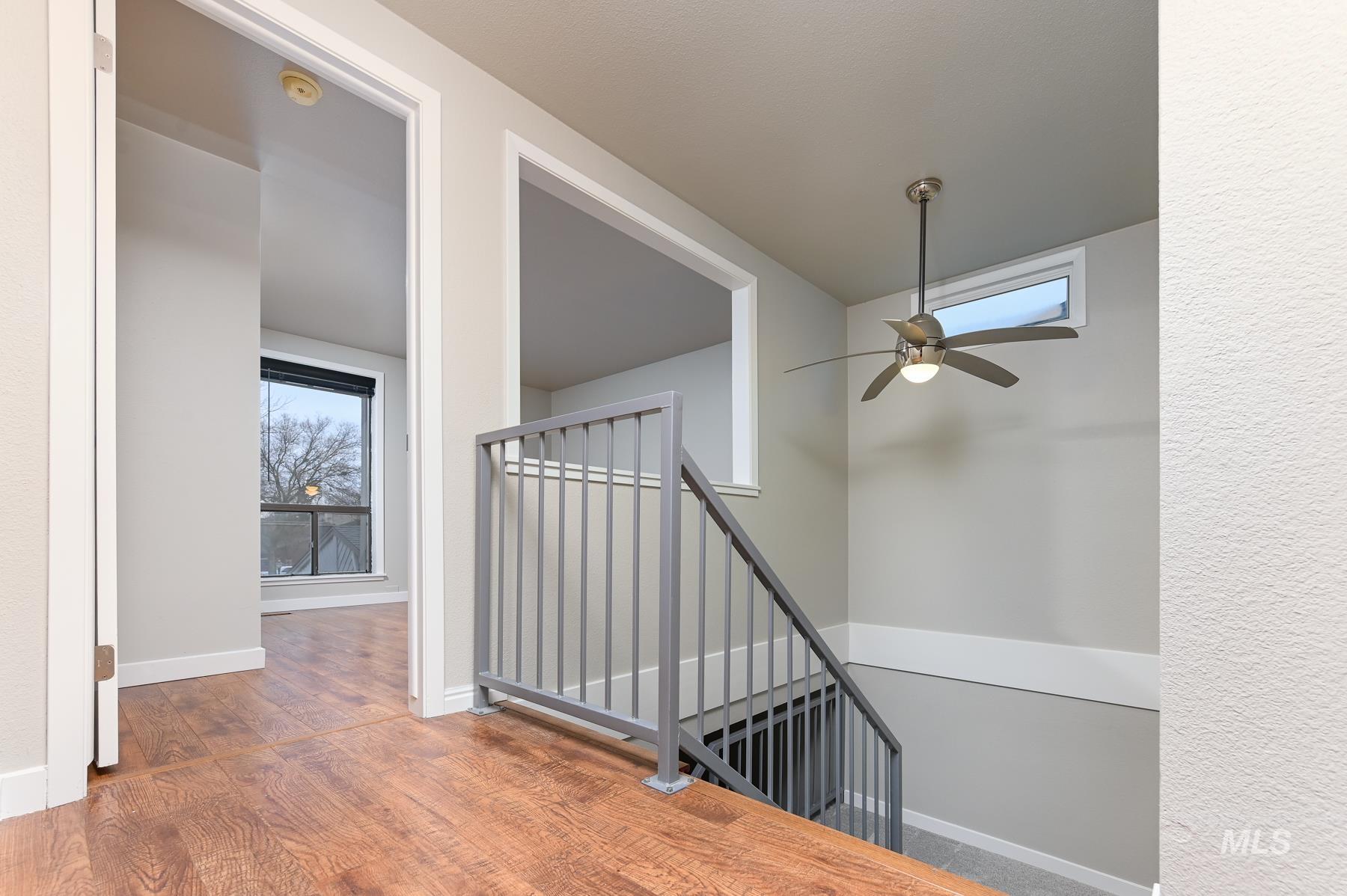 Staircase with ceiling fan and wood finished floors