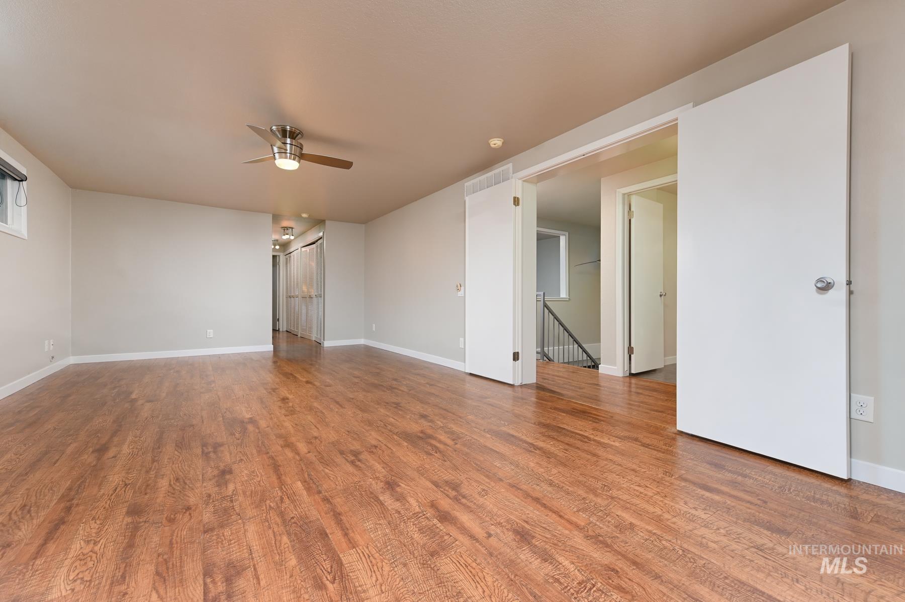 Unfurnished room with a ceiling fan and light wood-style flooring