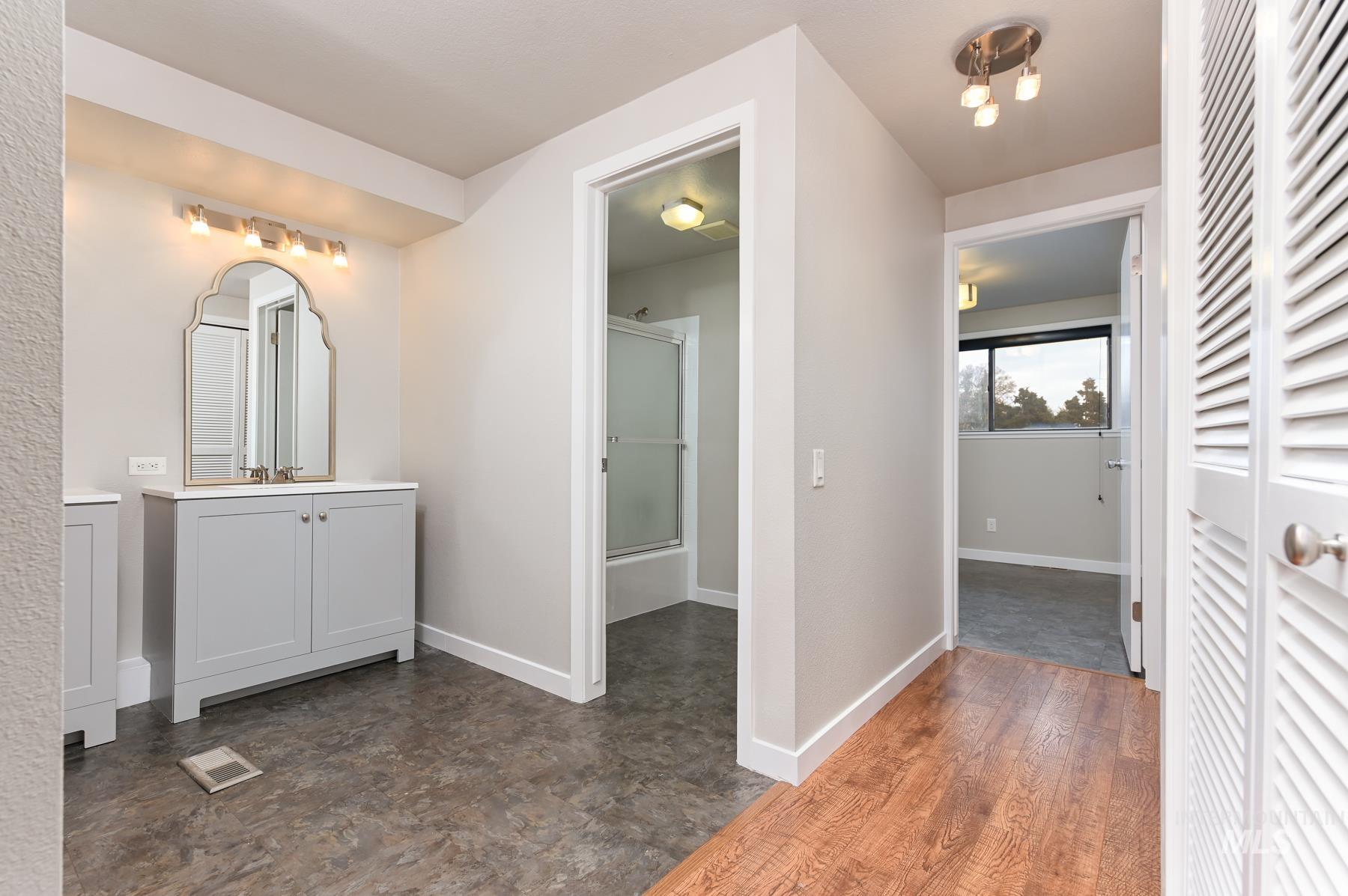 Full bathroom with a closet, vanity, and enclosed tub / shower combo