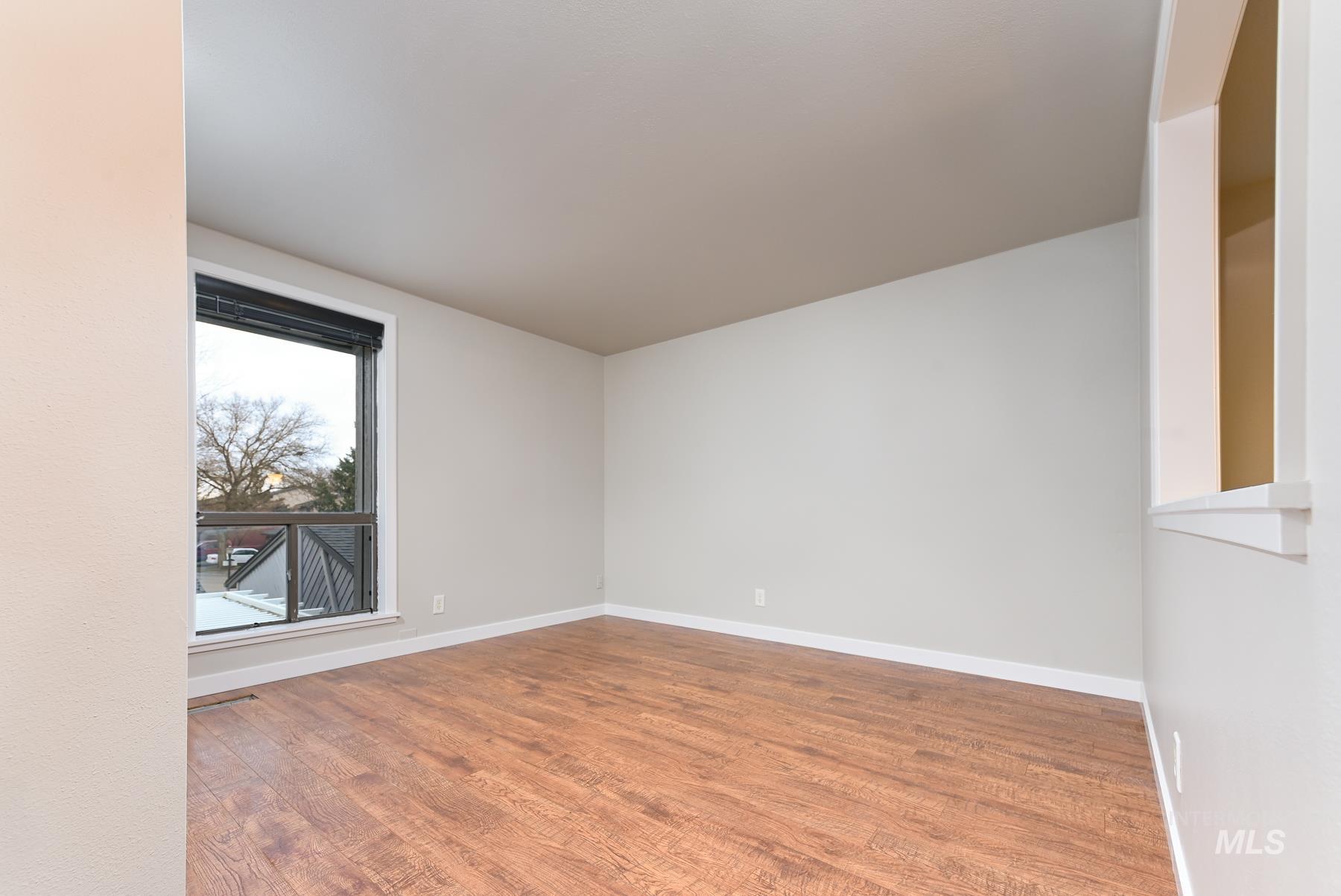 Empty room featuring wood finished floors and baseboards