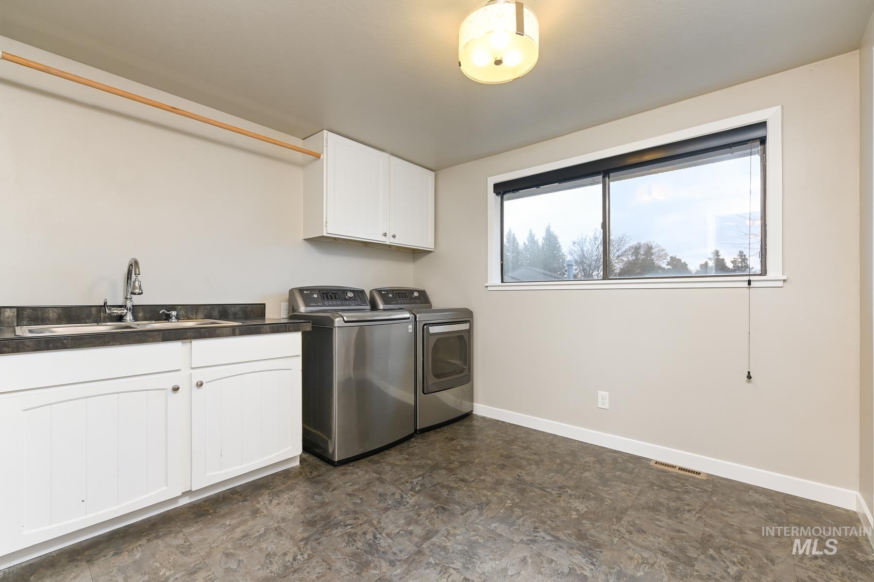 Laundry room with cabinet space and washer and clothes dryer