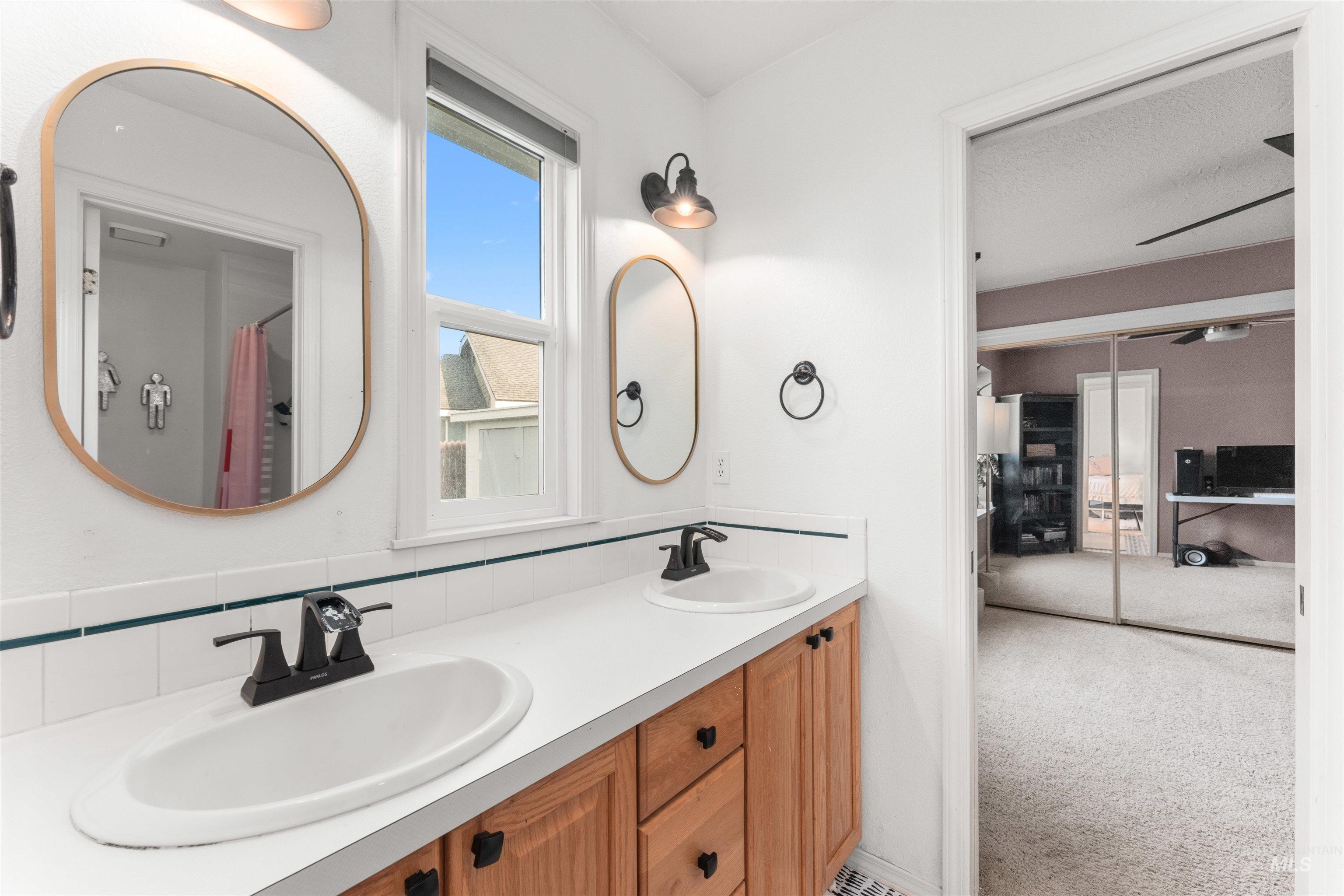Jack and Jill featuring light carpet, curtained shower, and double vanity
