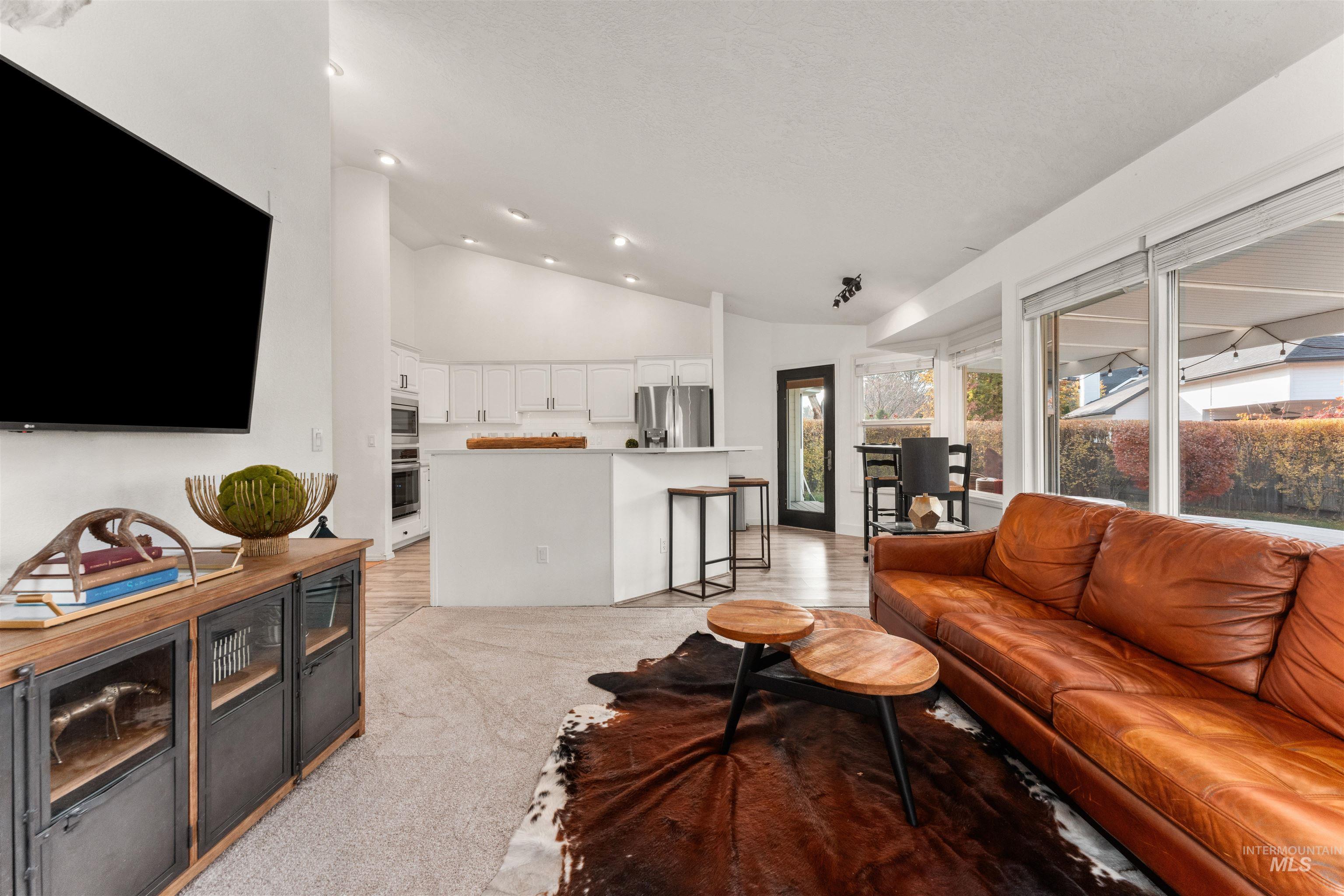 Living room featuring lofted ceiling, light colored carpet, and recessed lighting