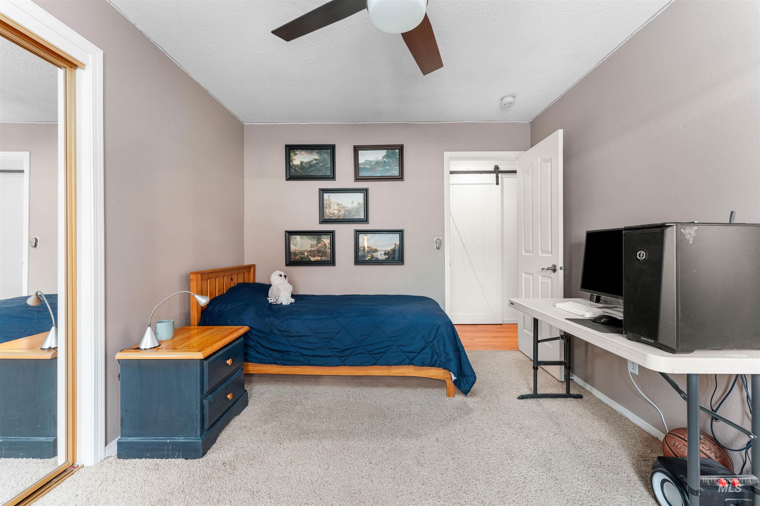 Bedroom featuring light colored carpet, ceiling fan, and a textured ceiling