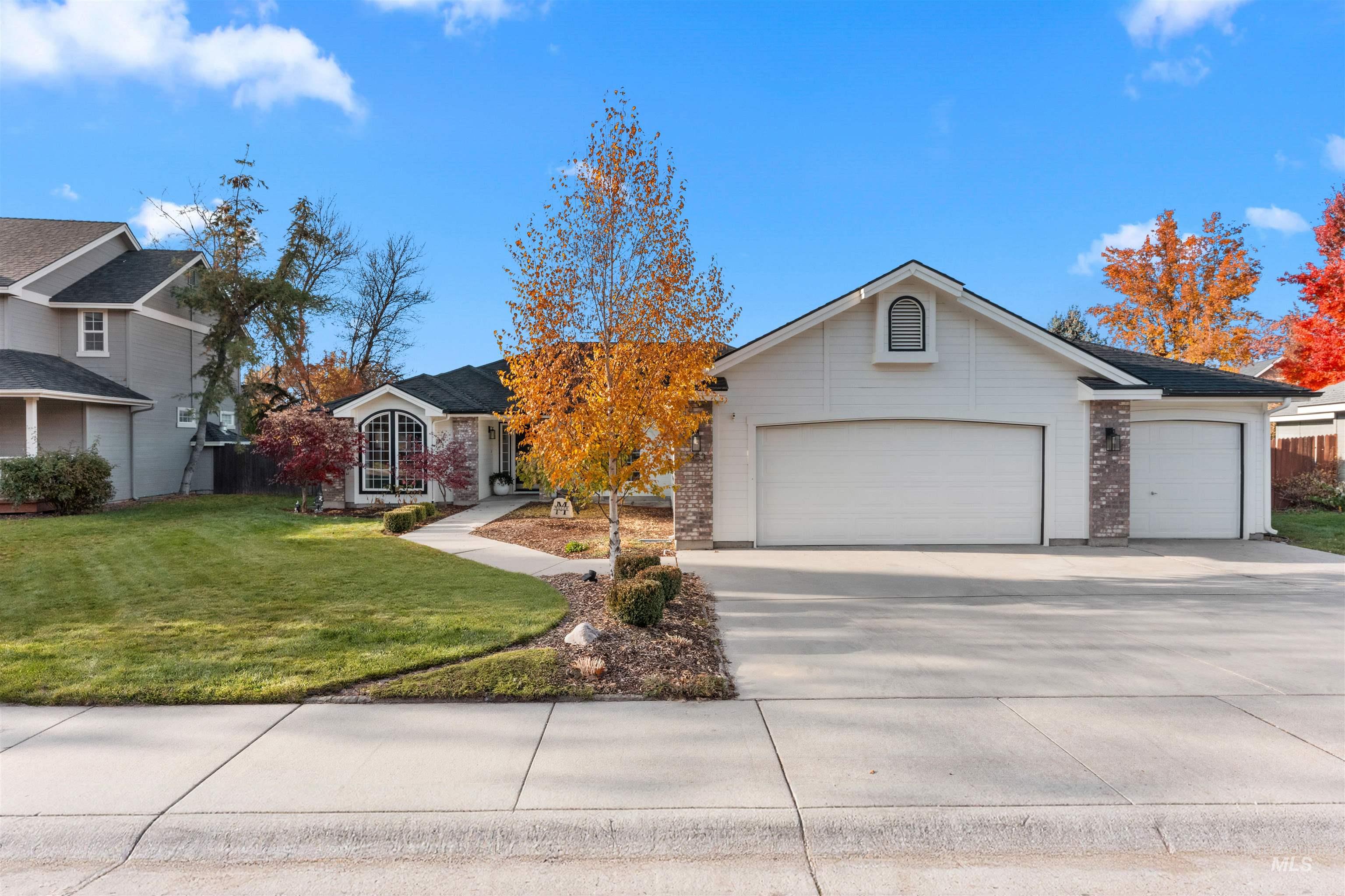 View of front of property with driveway, a garage, and brick siding
