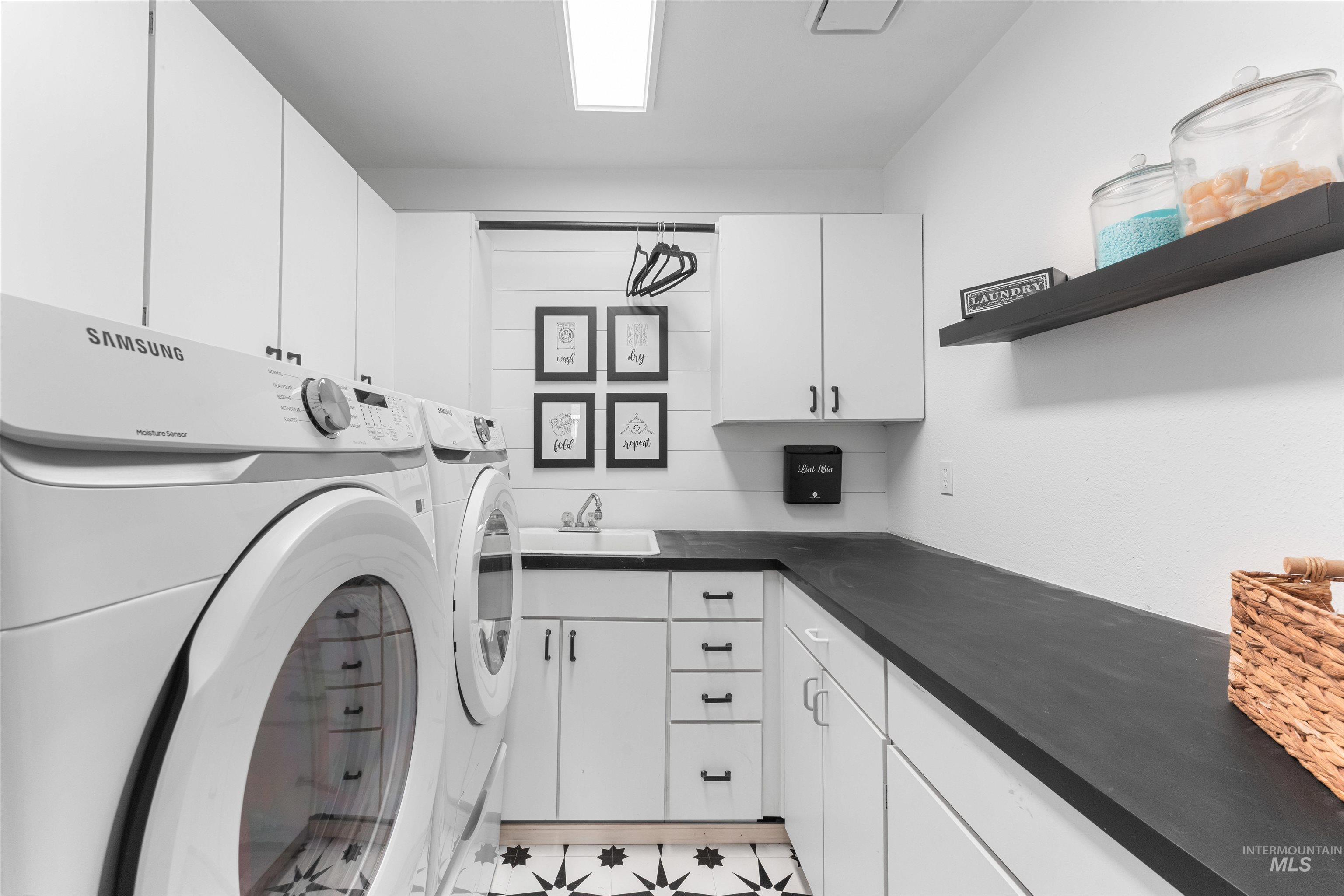 Washroom featuring cabinet space and independent washer and dryer