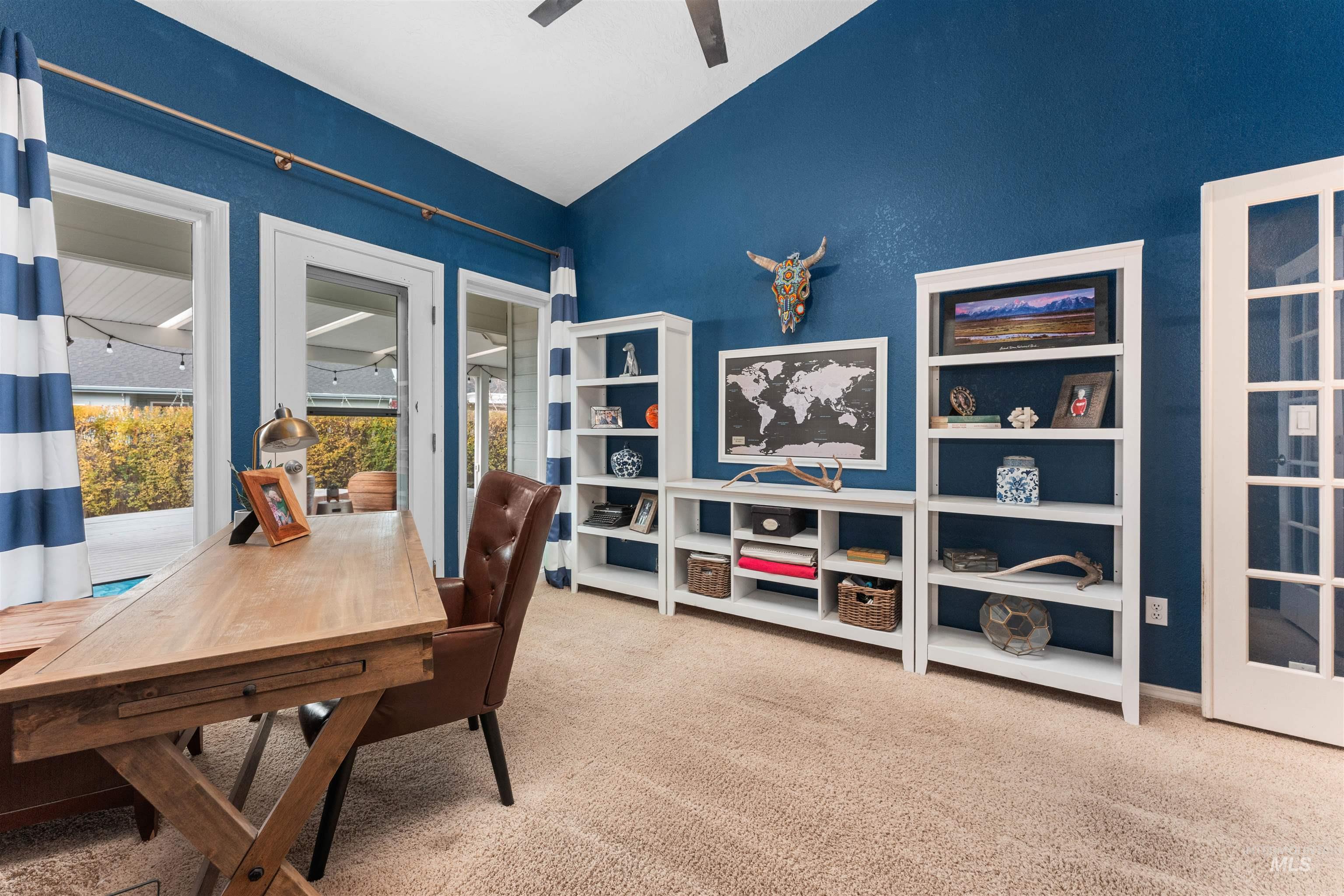 Office space featuring light colored carpet, ceiling fan, and lofted ceiling