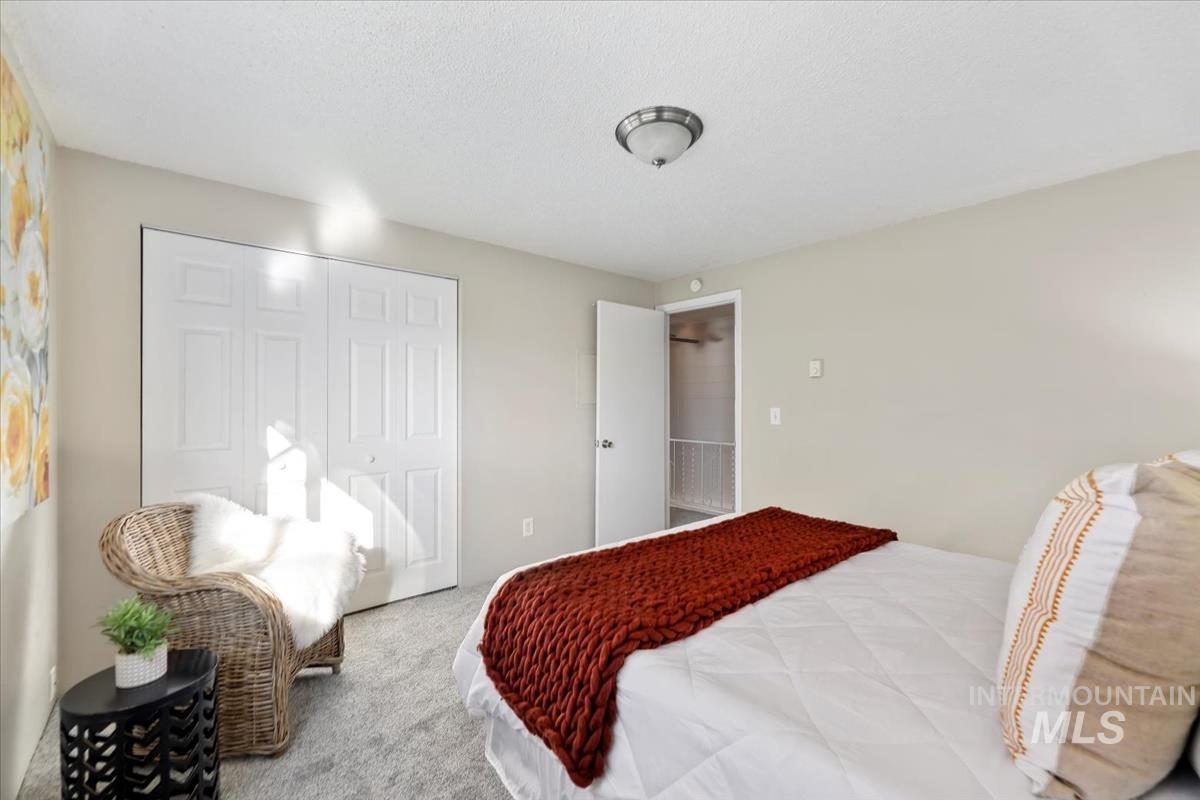 Carpeted bedroom with a closet and a textured ceiling