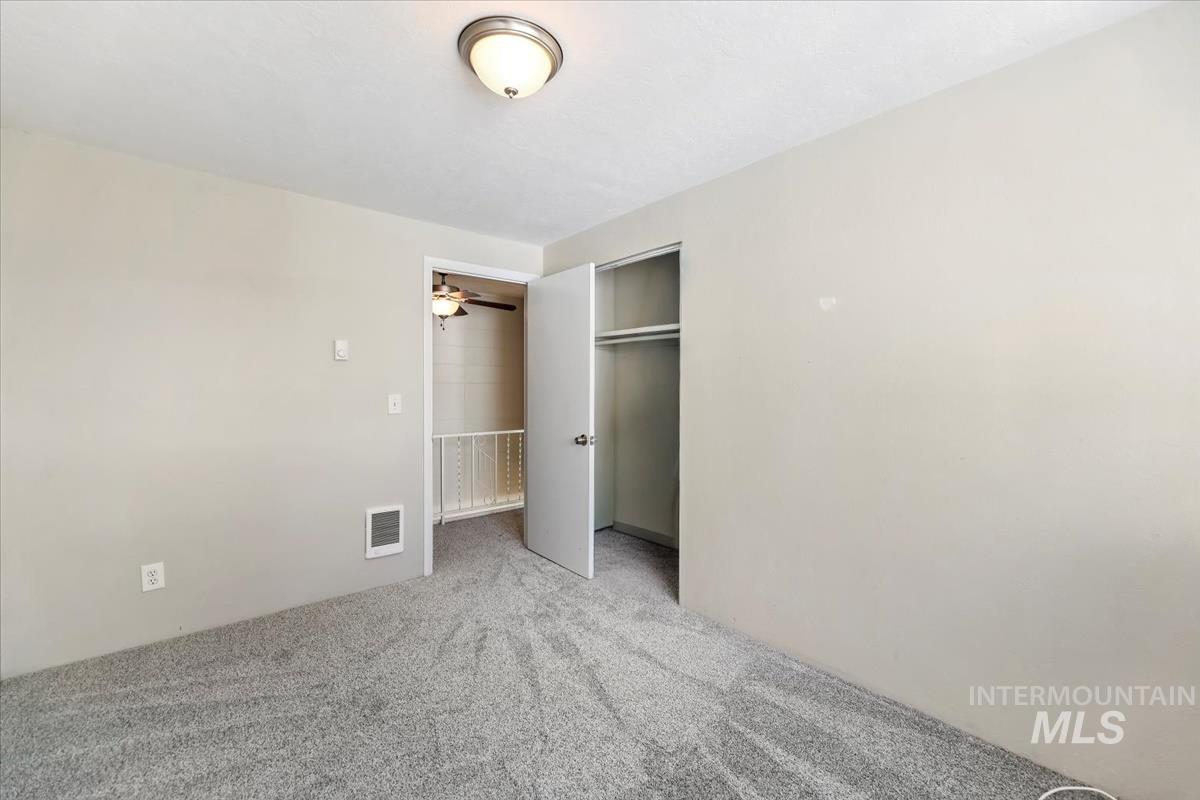 Unfurnished bedroom with a closet and light colored carpet