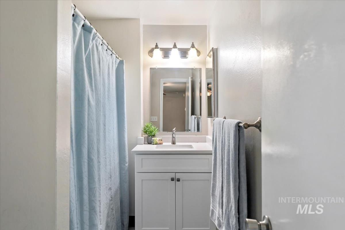 Bathroom featuring a shower with shower curtain and vanity