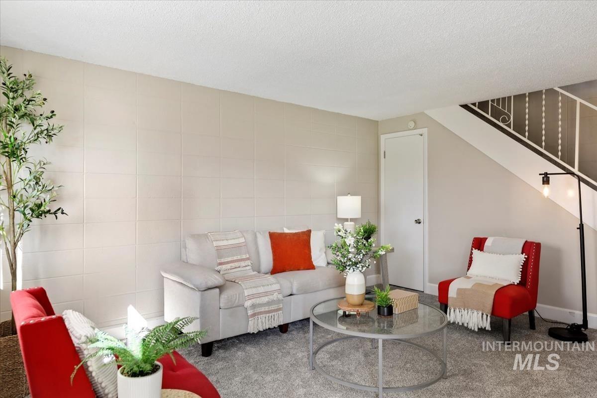 Living room with tile walls, stairway, and a textured ceiling