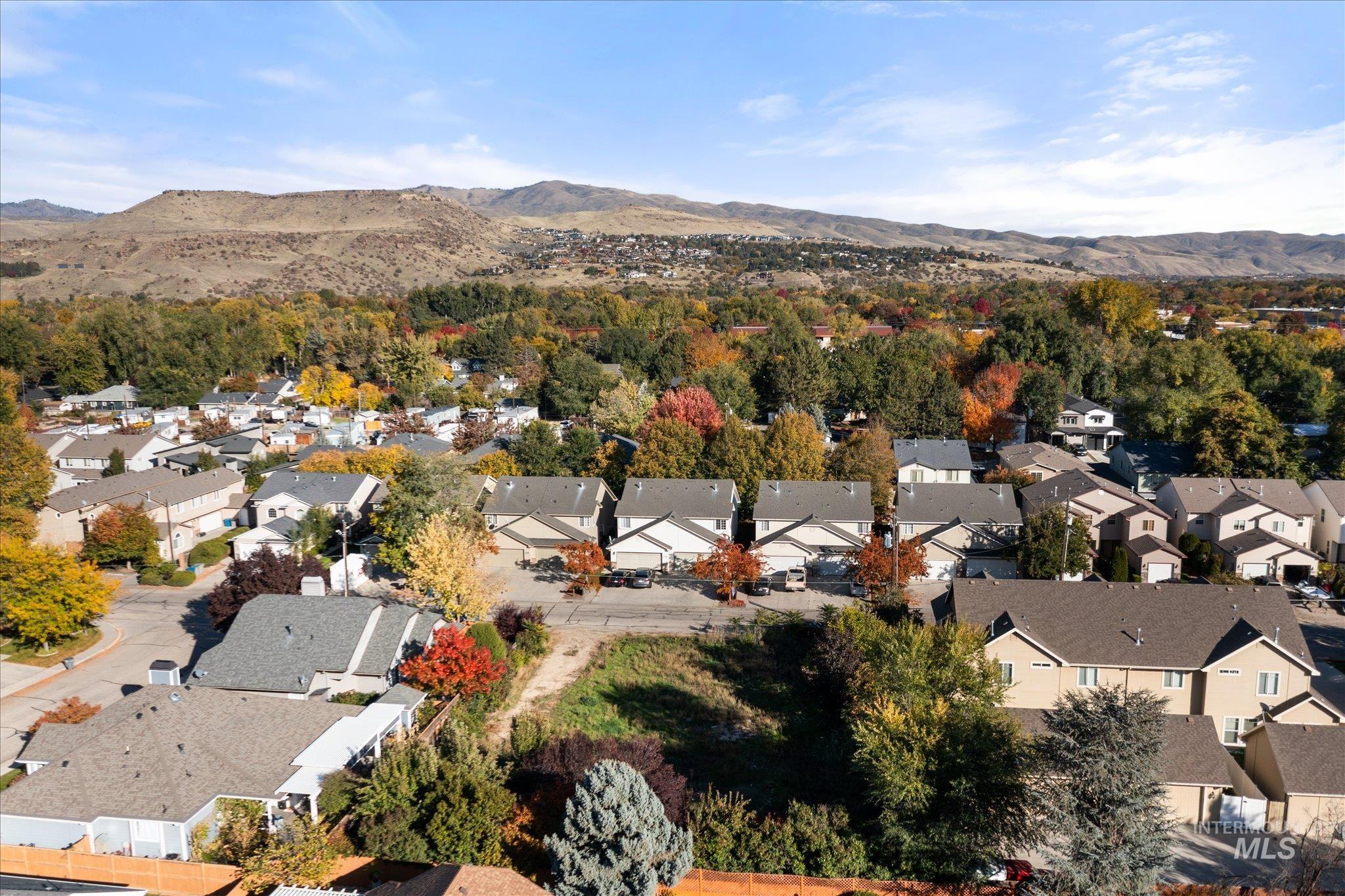 Aerial view of property's location featuring a mountainous background and nearby suburban area