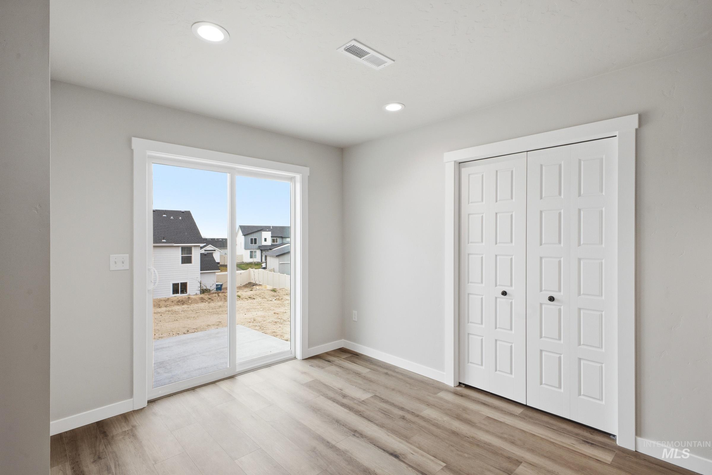 Room featuring wood-finish flooring, recessed lighting, and a sliding glass door