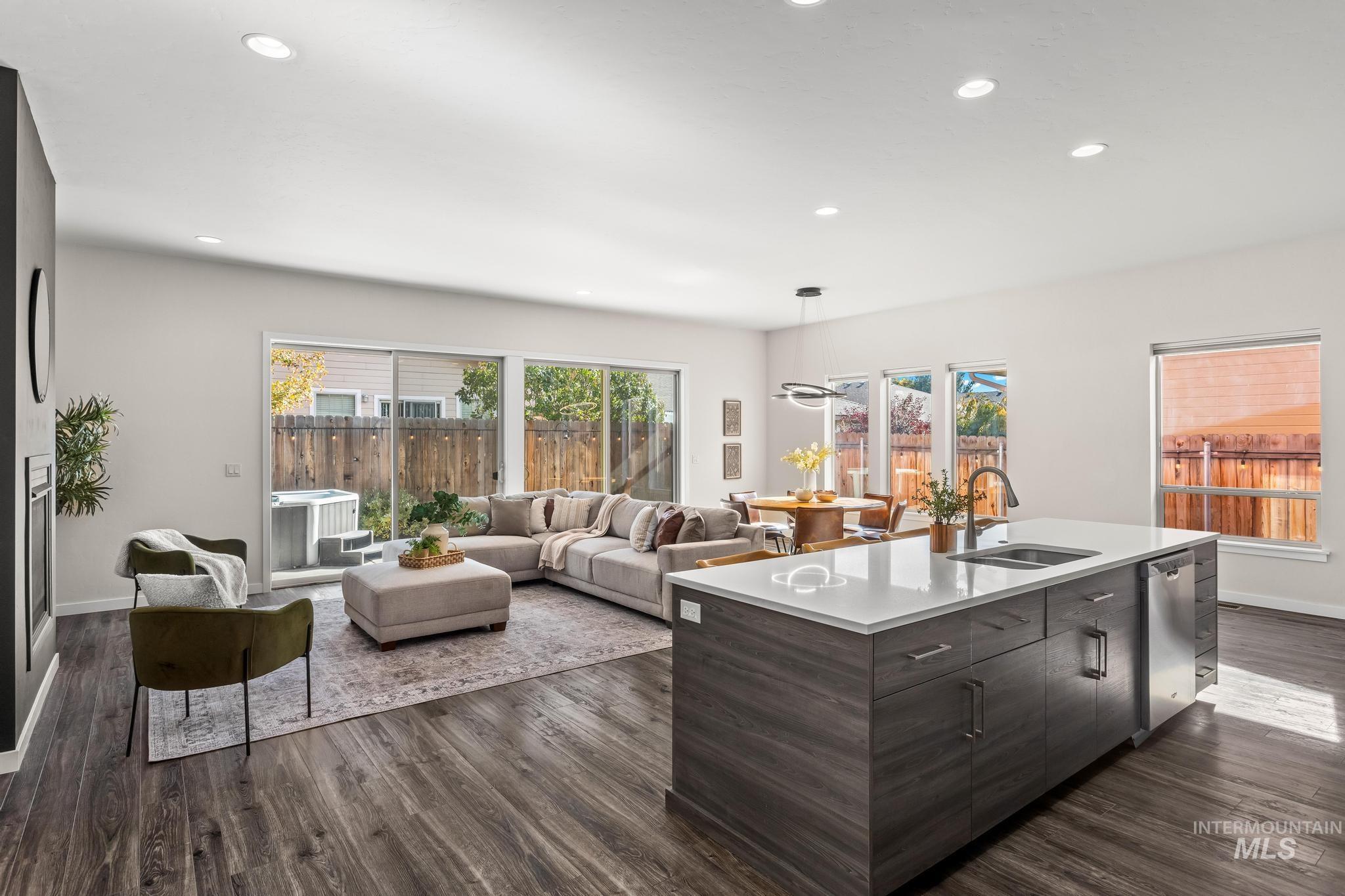 Kitchen featuring dark brown cabinetry, dark wood-style floors, recessed lighting, an island with sink, and open floor plan