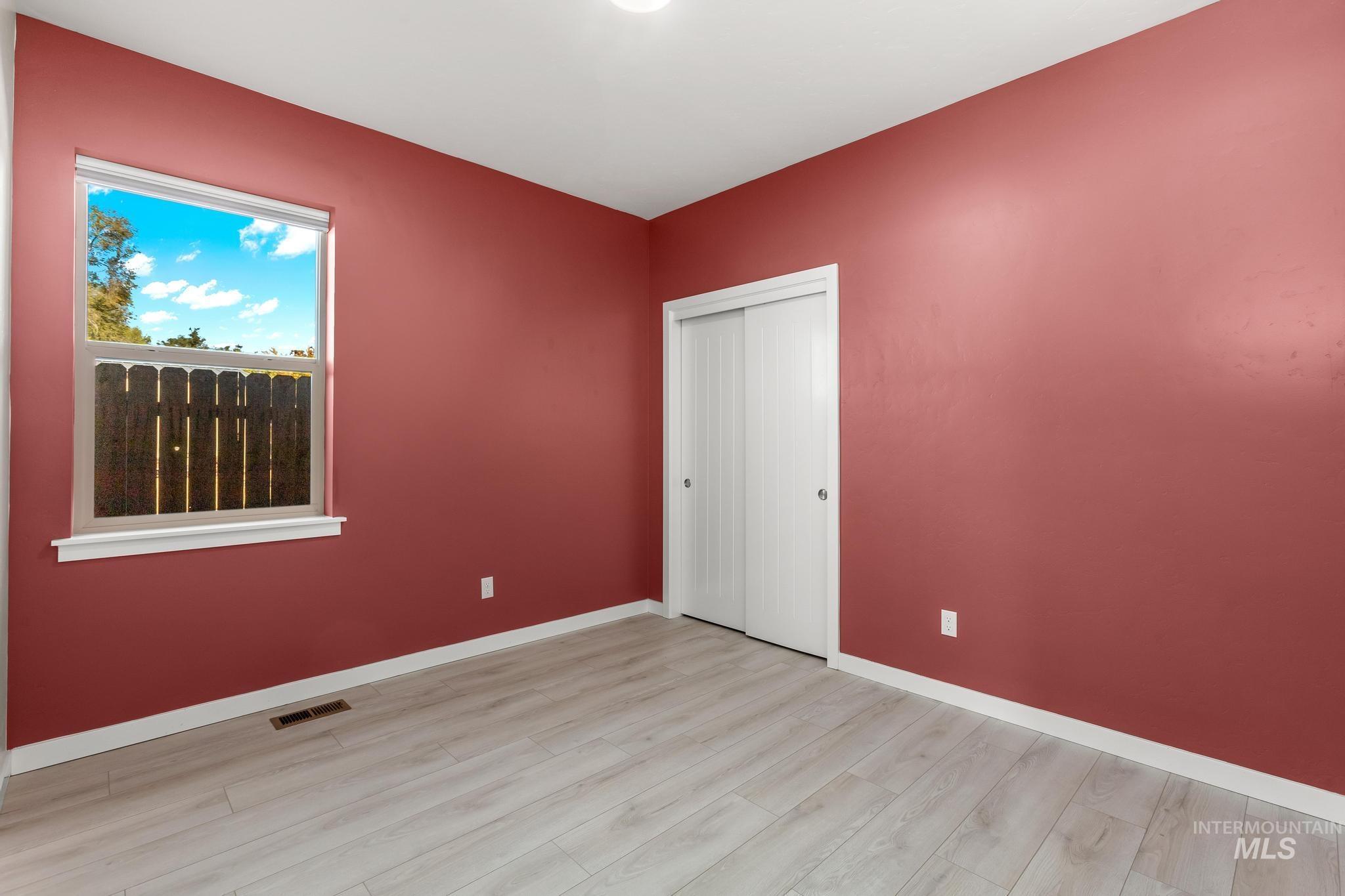 Unfurnished bedroom with light wood-style floors and a closet