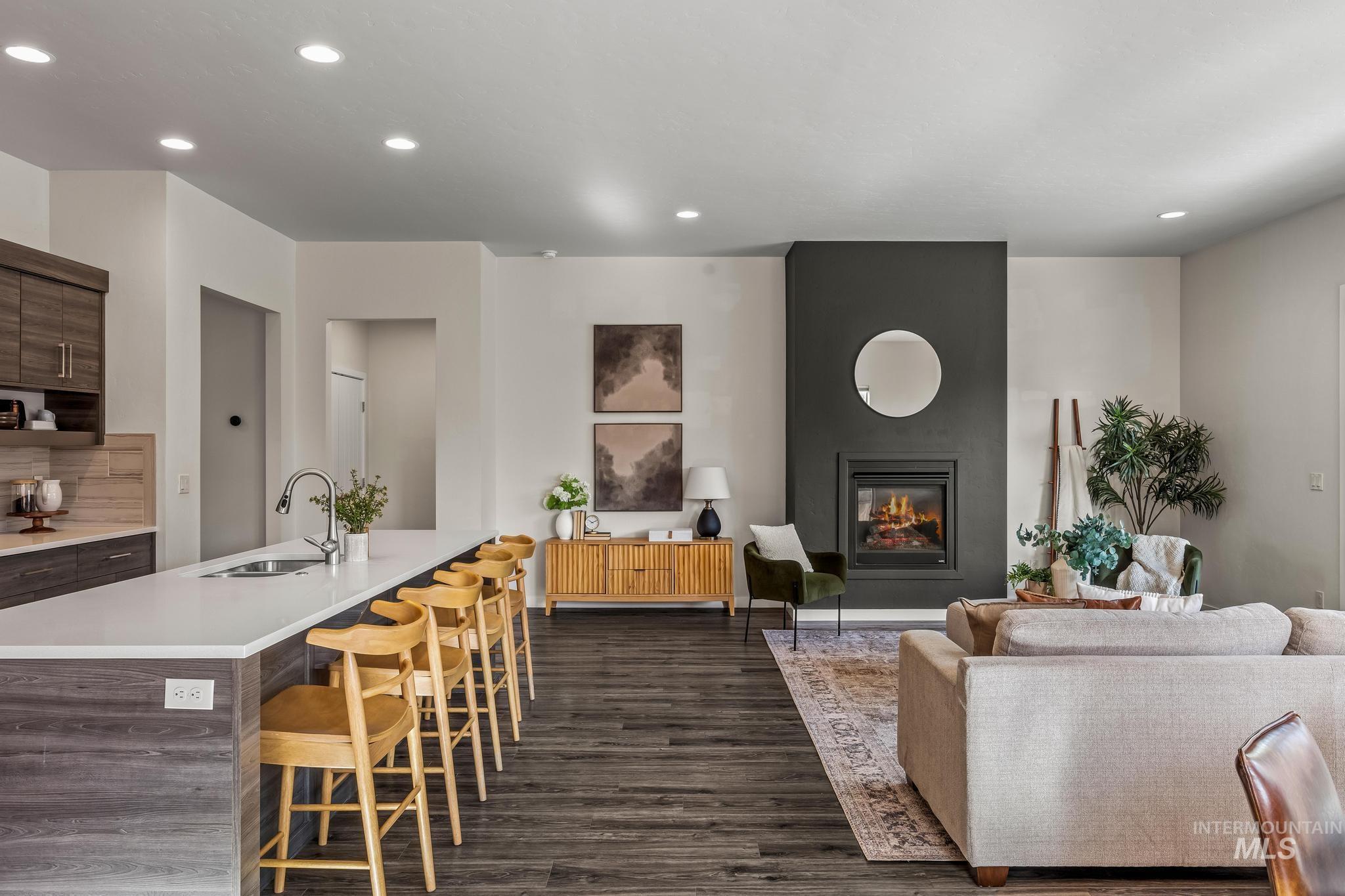 Living room featuring recessed lighting, dark wood-type flooring, and a fireplace