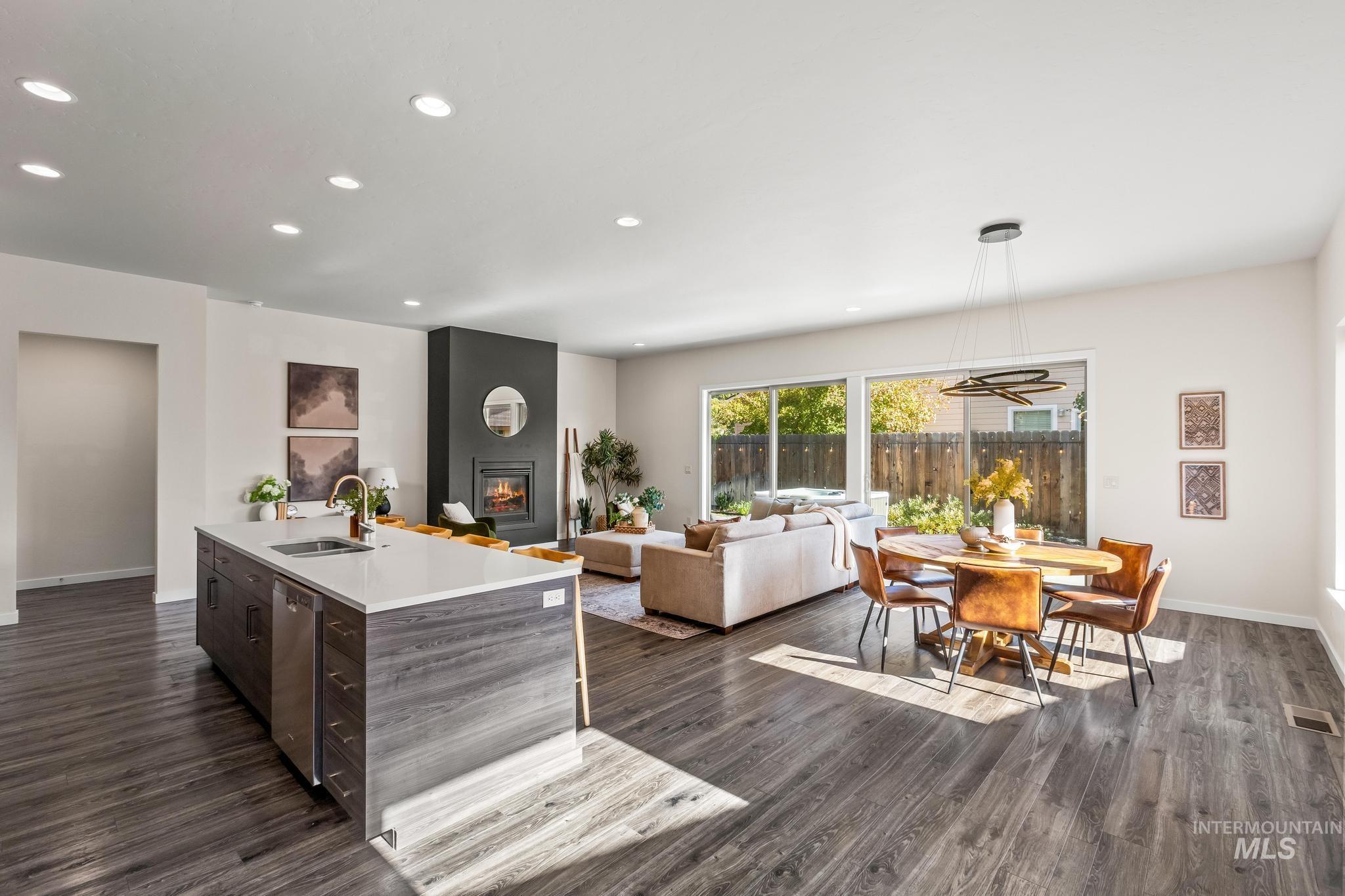 Kitchen featuring recessed lighting, dark brown cabinetry, dark wood finished floors, open floor plan, and a fireplace
