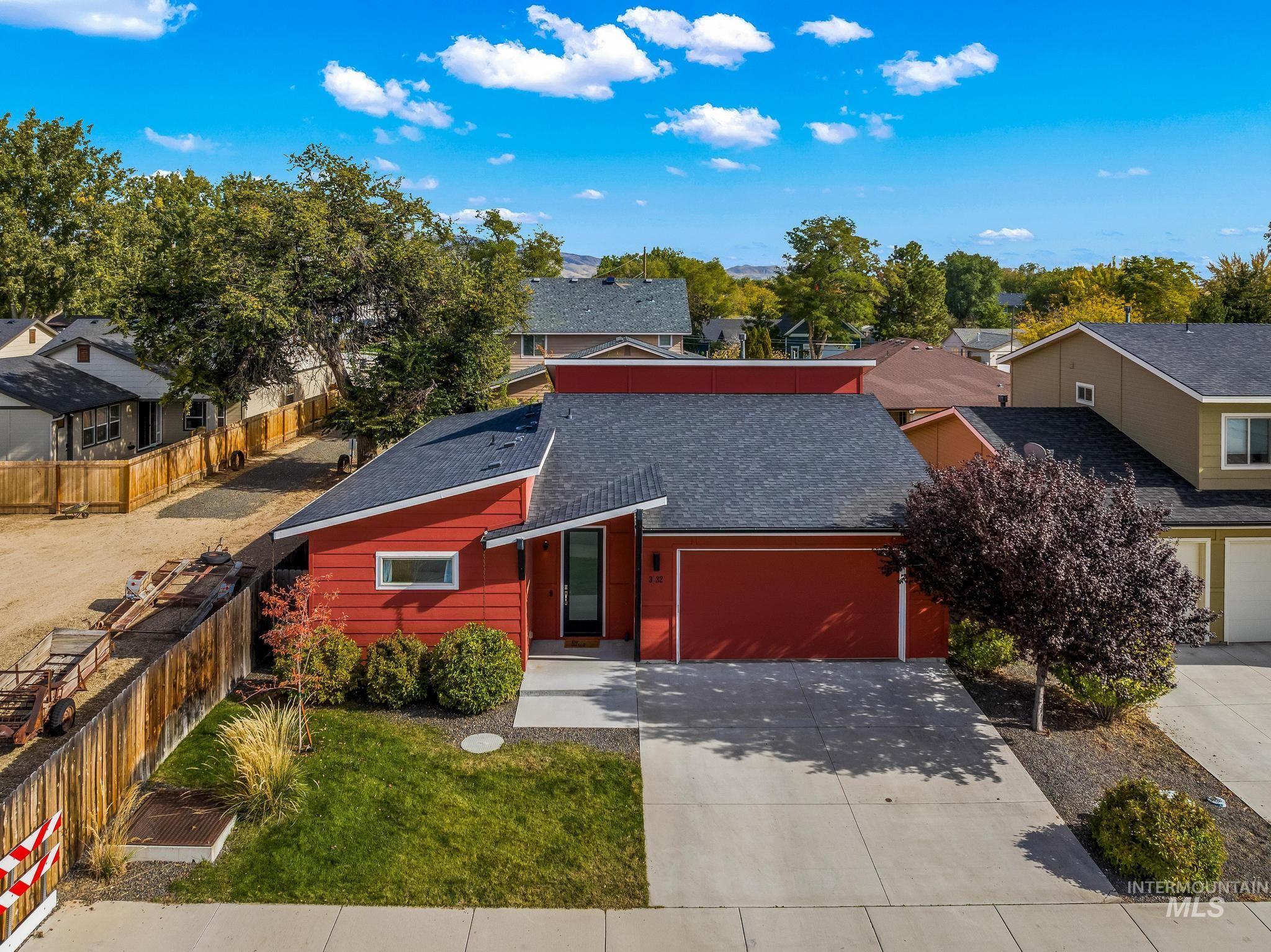 View of front of property with a shingled roof, a residential view, driveway, and a garage