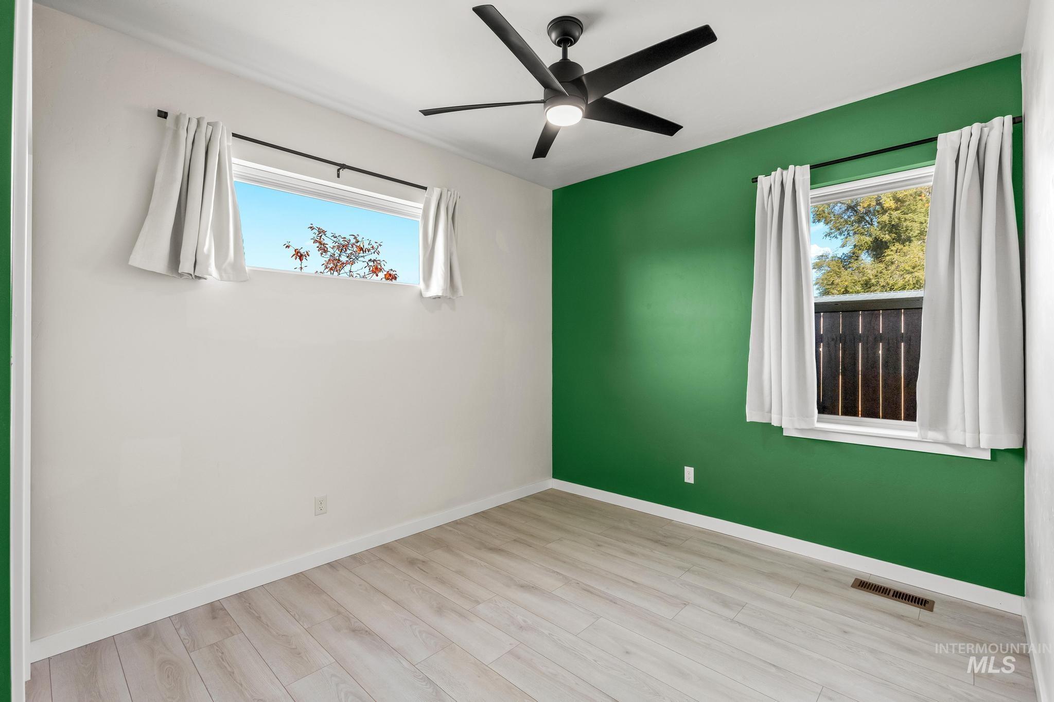 Empty room featuring wood finished floors and a ceiling fan