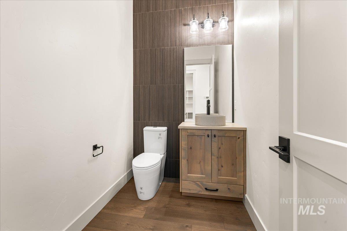 Bathroom featuring vanity, dark wood-style flooring, and tile walls