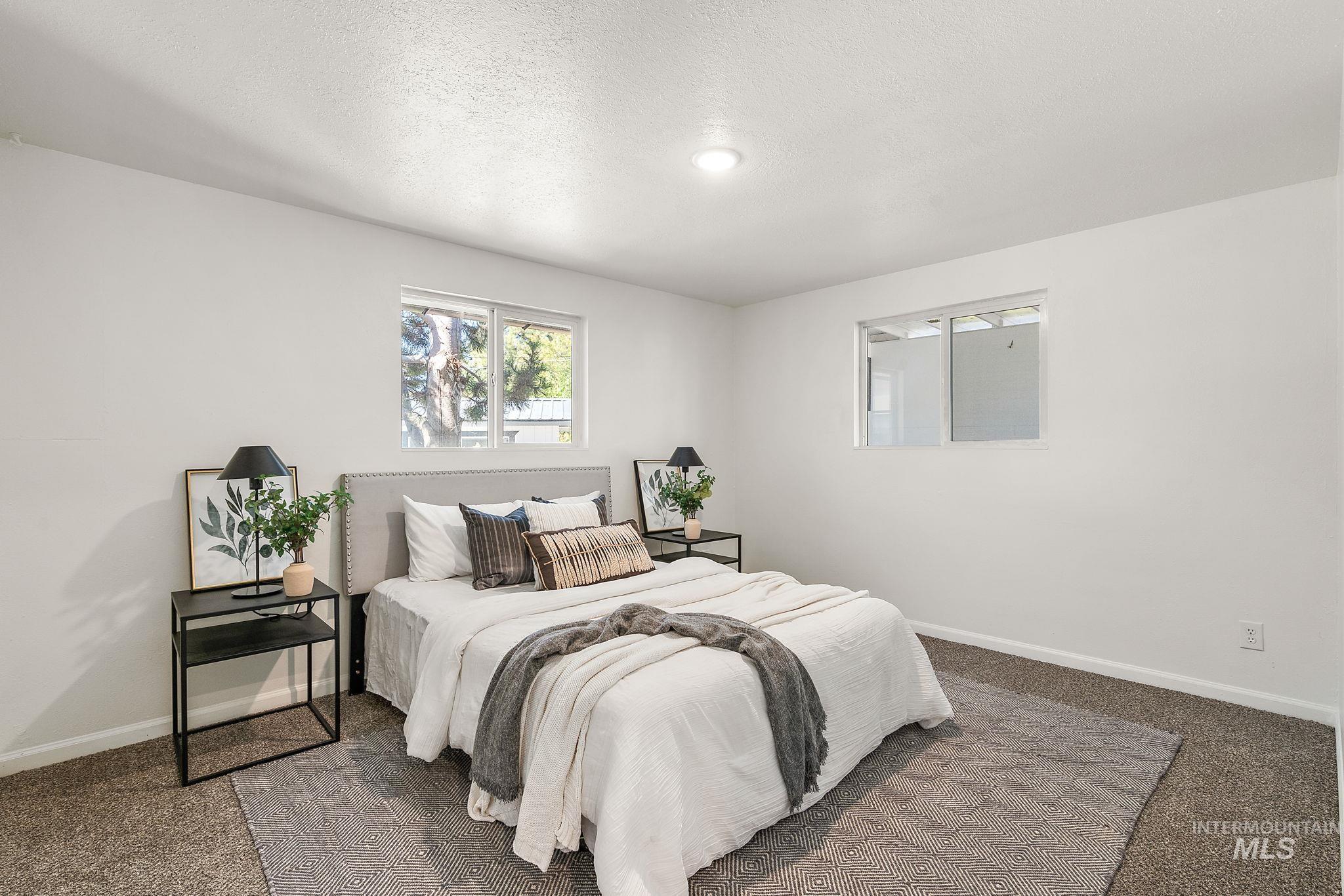 Carpeted bedroom featuring baseboards and a textured ceiling