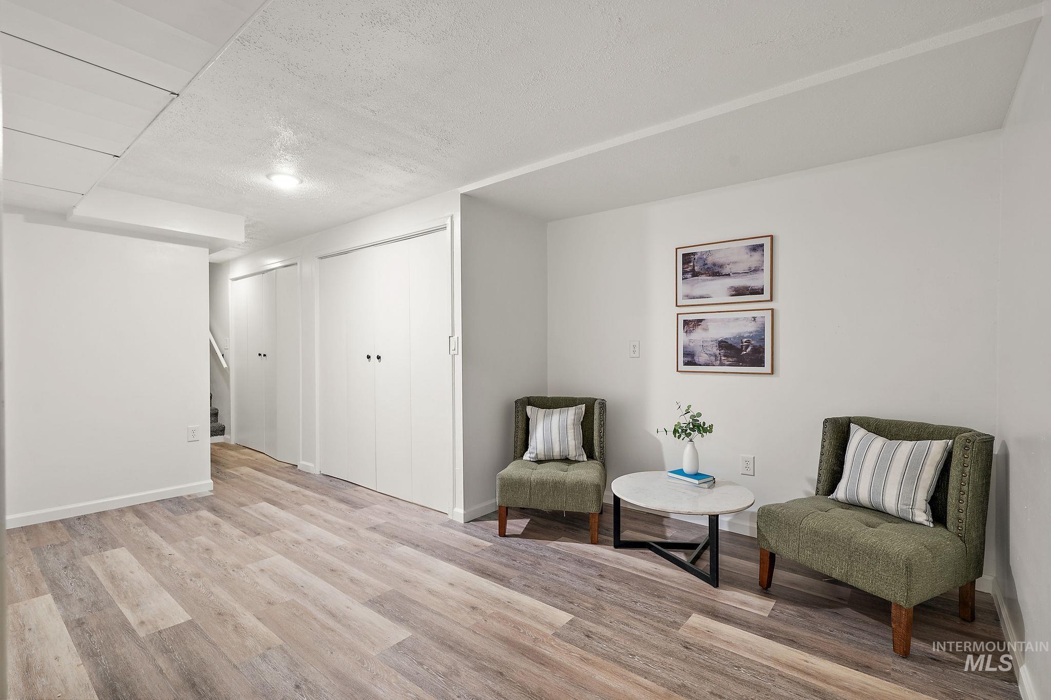 Sitting room with a textured ceiling and wood finished floors