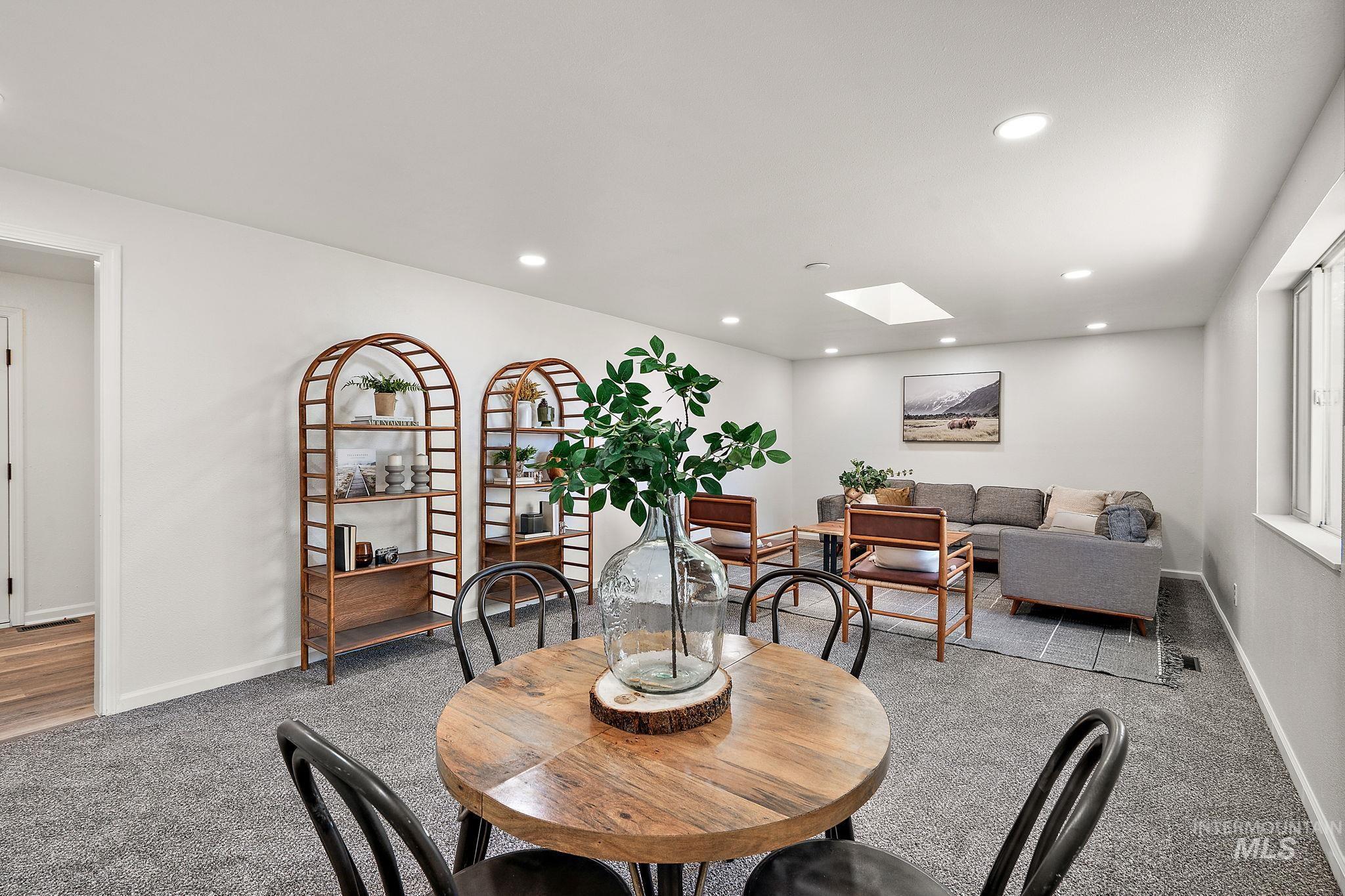 Dining space featuring a skylight, light colored carpet, and recessed lighting
