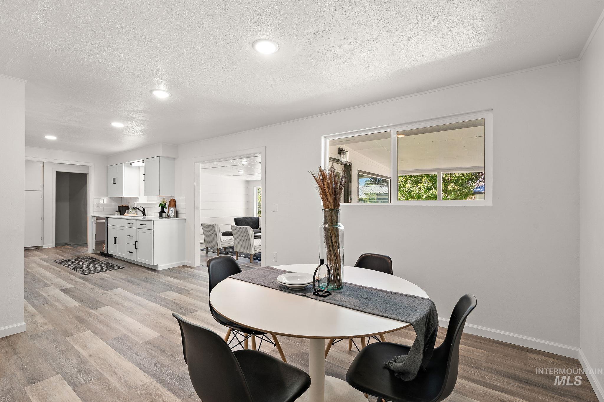 Dining space featuring a textured ceiling, light wood-style floors, and recessed lighting