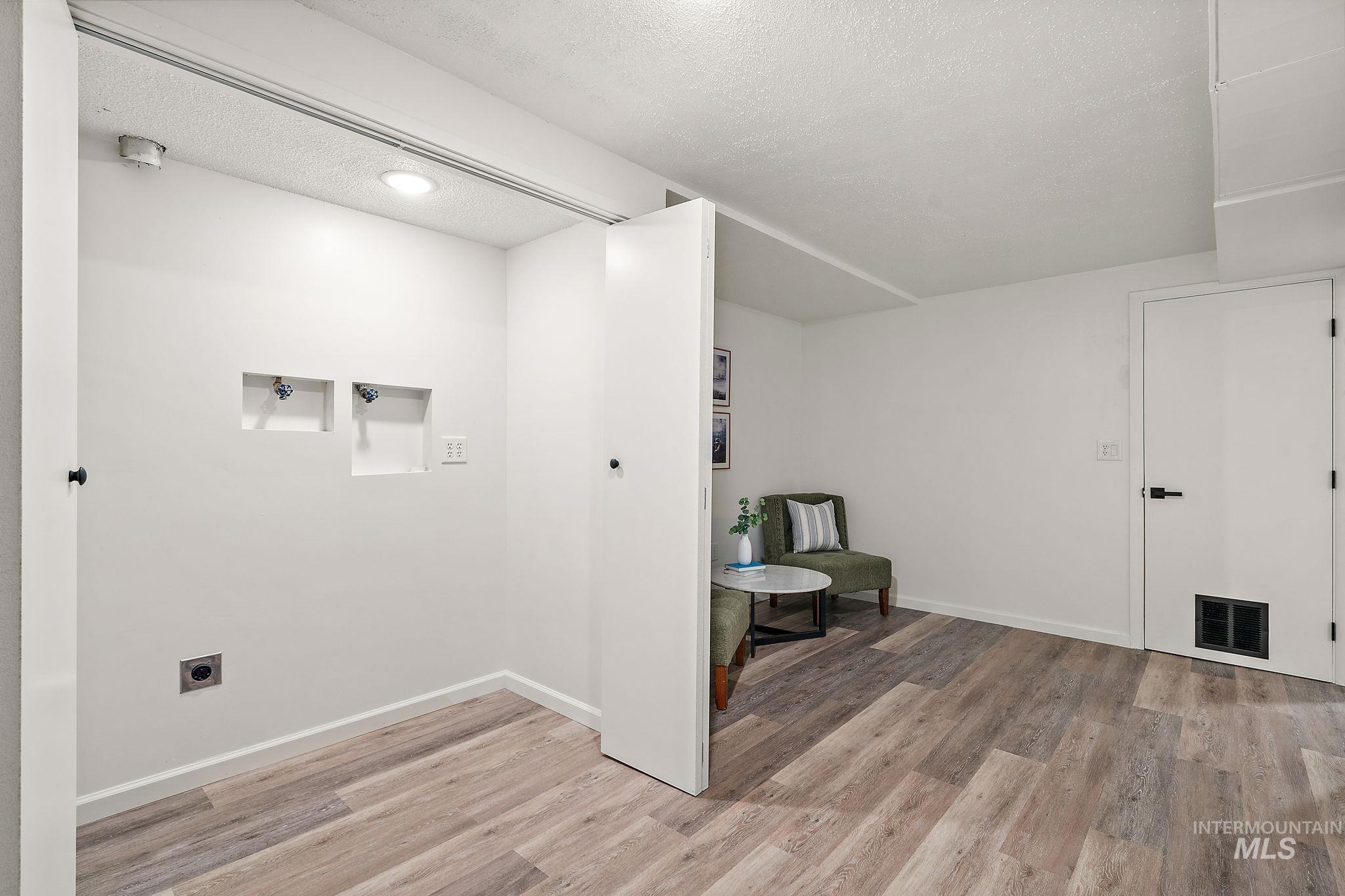 Unfurnished room featuring light wood-style floors and a textured ceiling