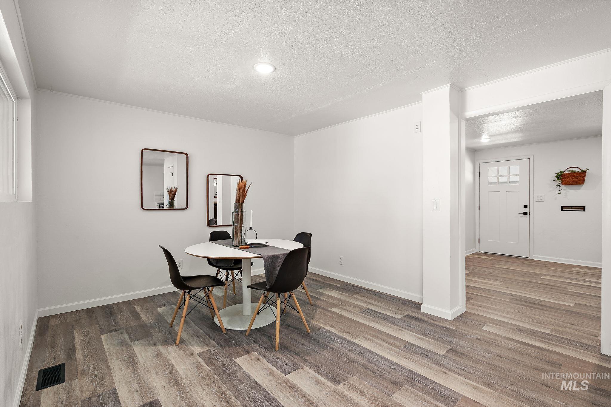 Dining room featuring light wood-type flooring and a textured ceiling