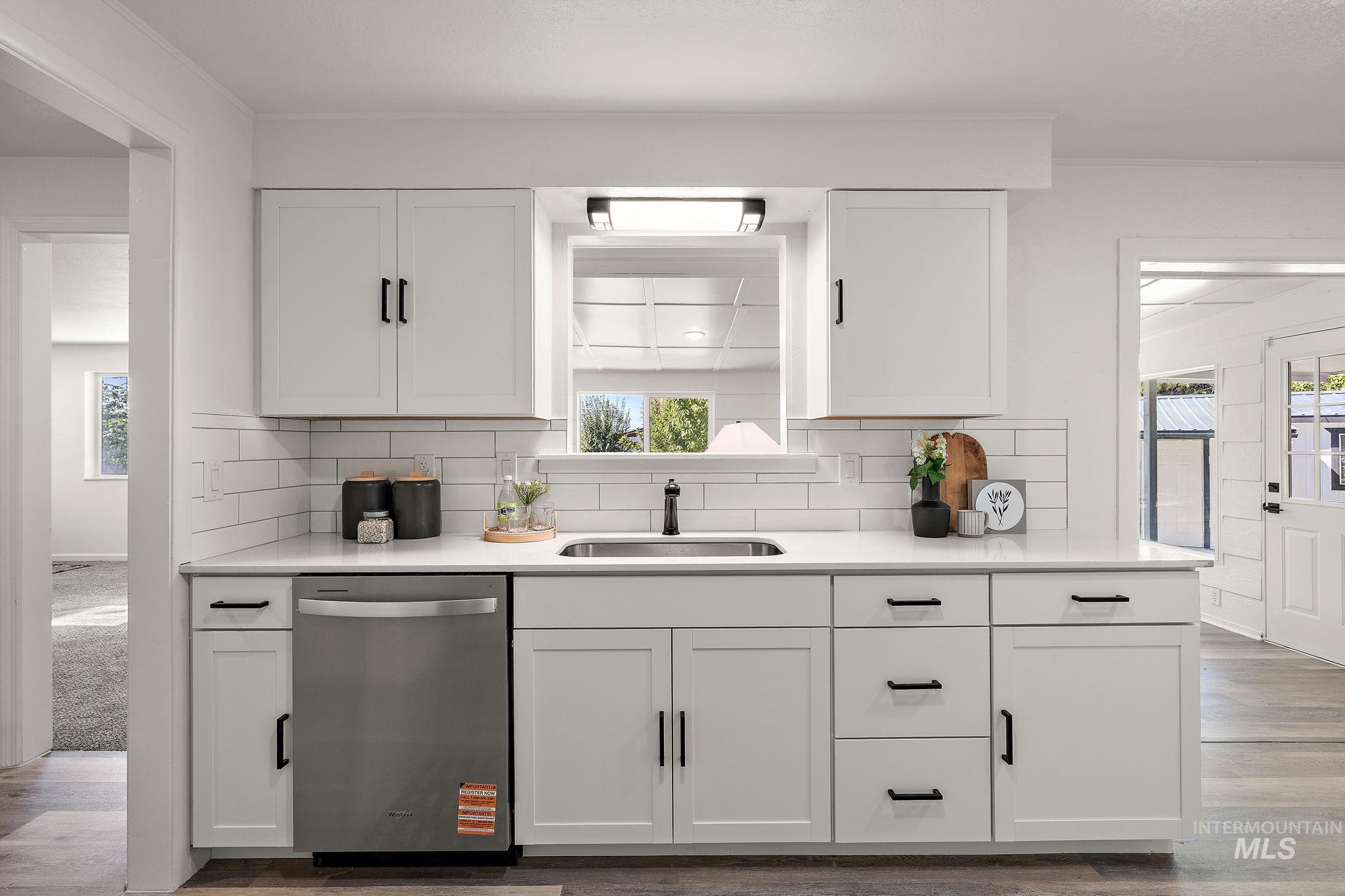 Kitchen featuring white cabinets, stainless steel dishwasher, and healthy amount of natural light