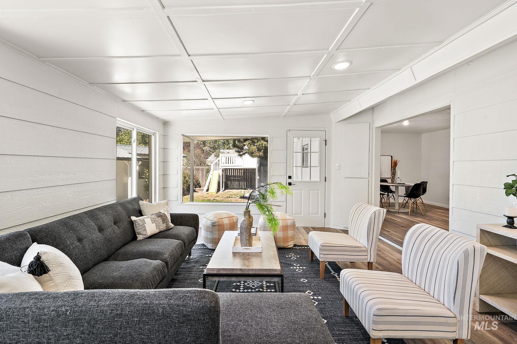Living room with wood walls, wood finished floors, and recessed lighting