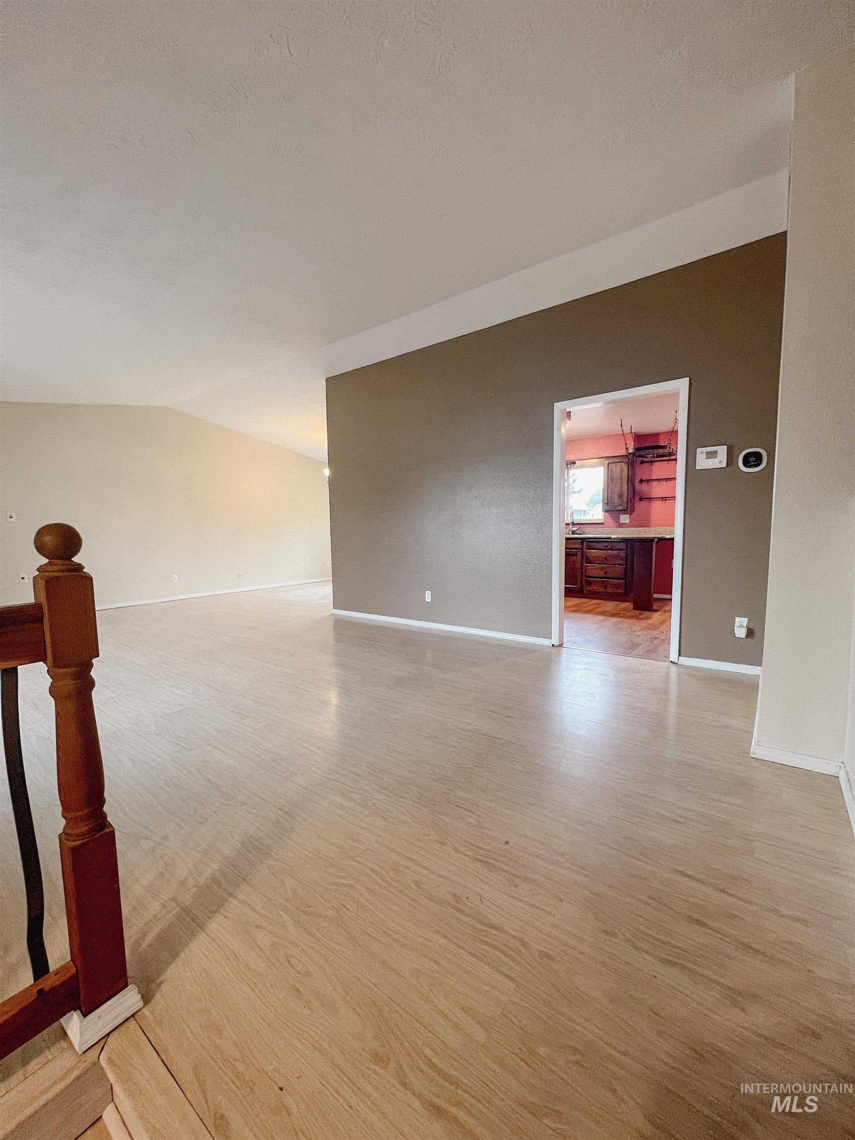 Unfurnished room featuring light wood-style floors and a textured ceiling