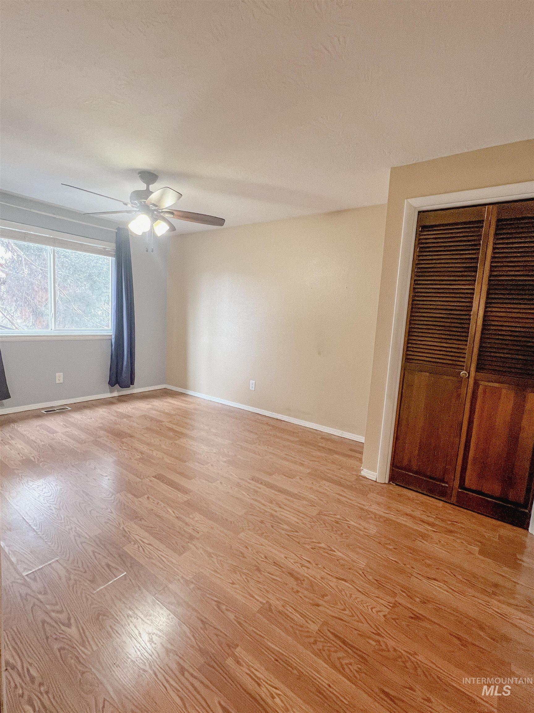 Unfurnished room with light wood-style floors and ceiling fan