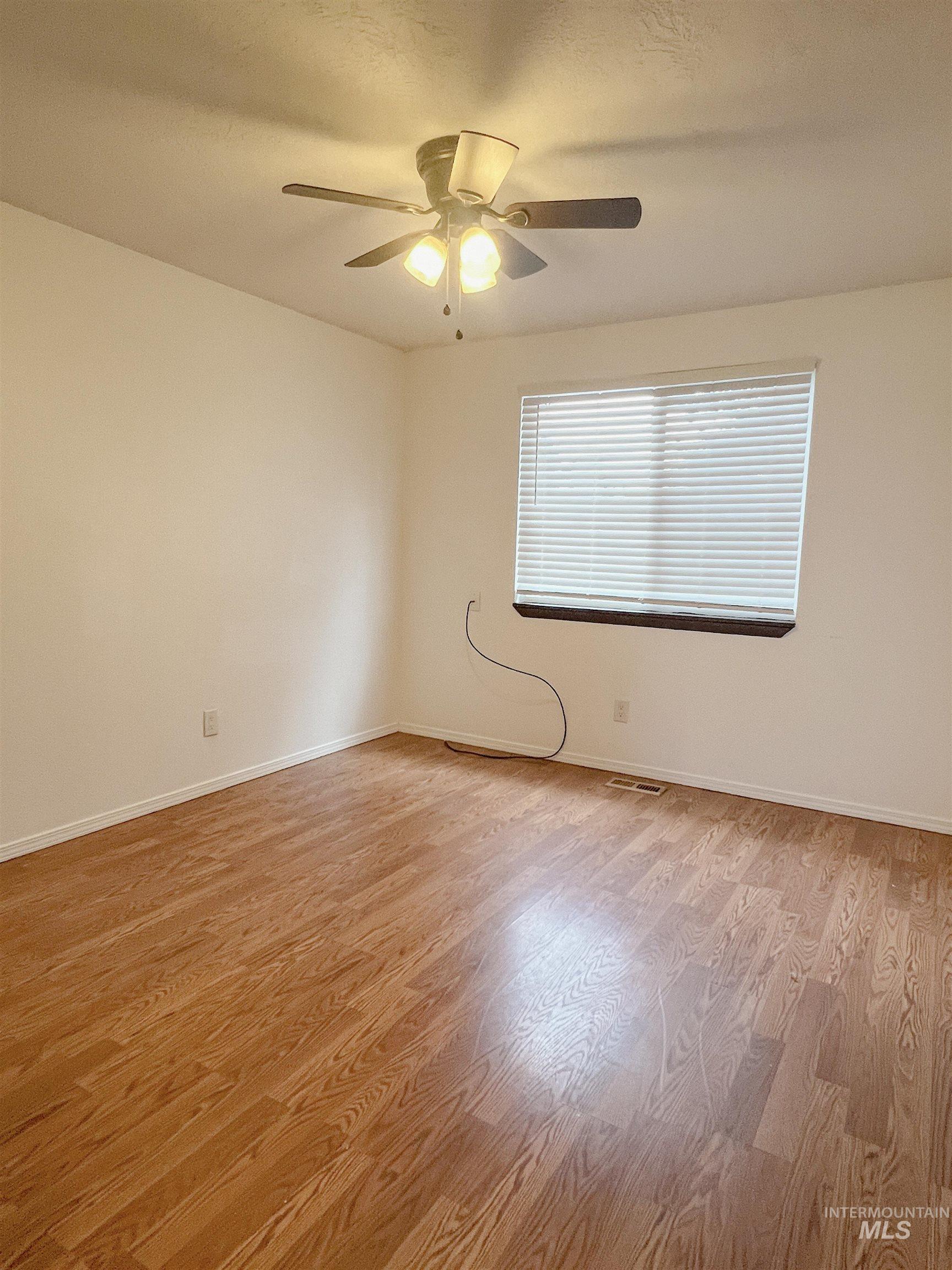 Unfurnished room featuring light wood-style floors and a ceiling fan
