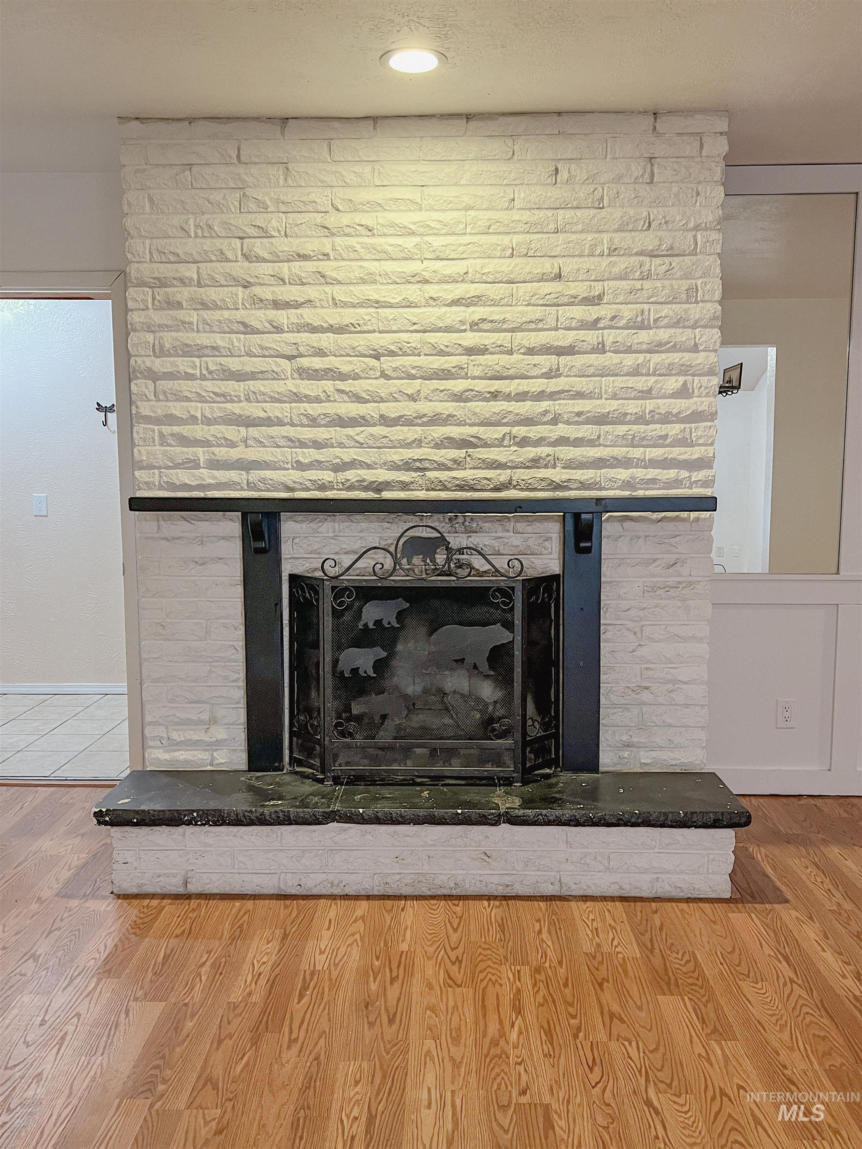 Detailed view of a brick fireplace and wood finished floors