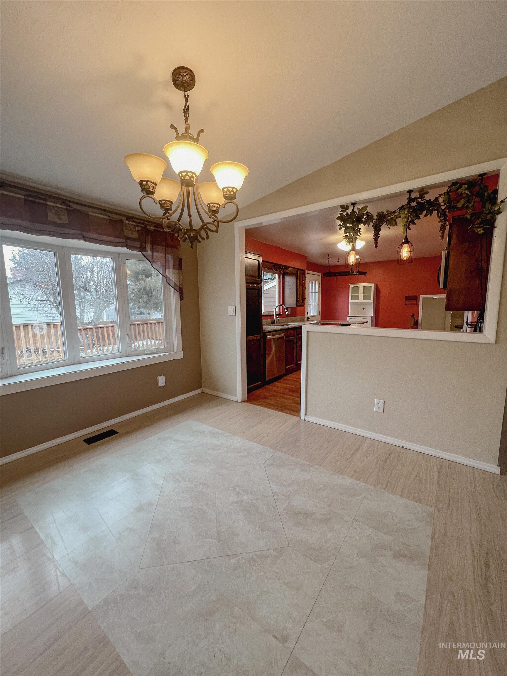 Unfurnished dining area with suspended lighting and light wood-style flooring
