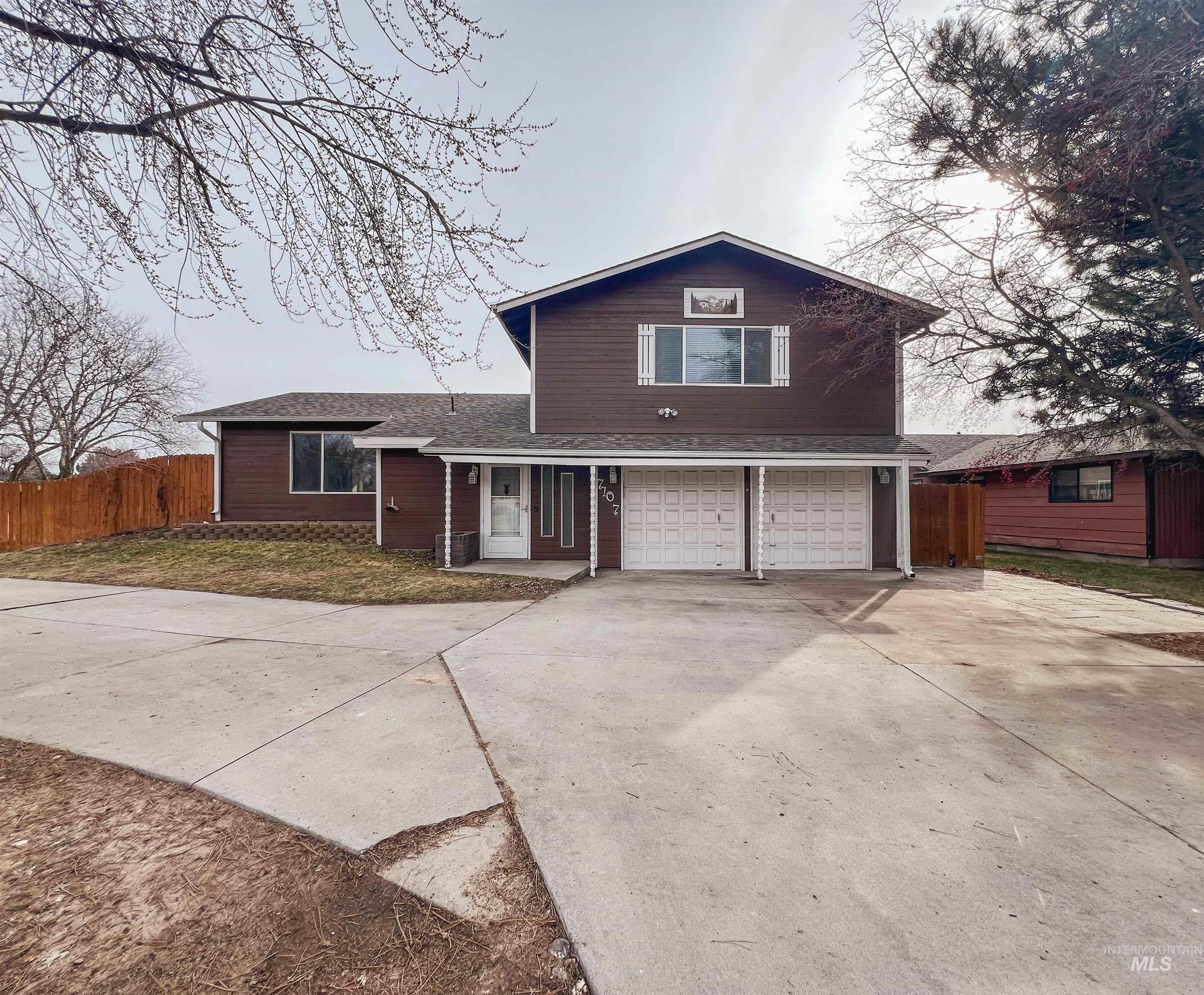 View of front of home featuring a garage, concrete driveway, and roof with shingles