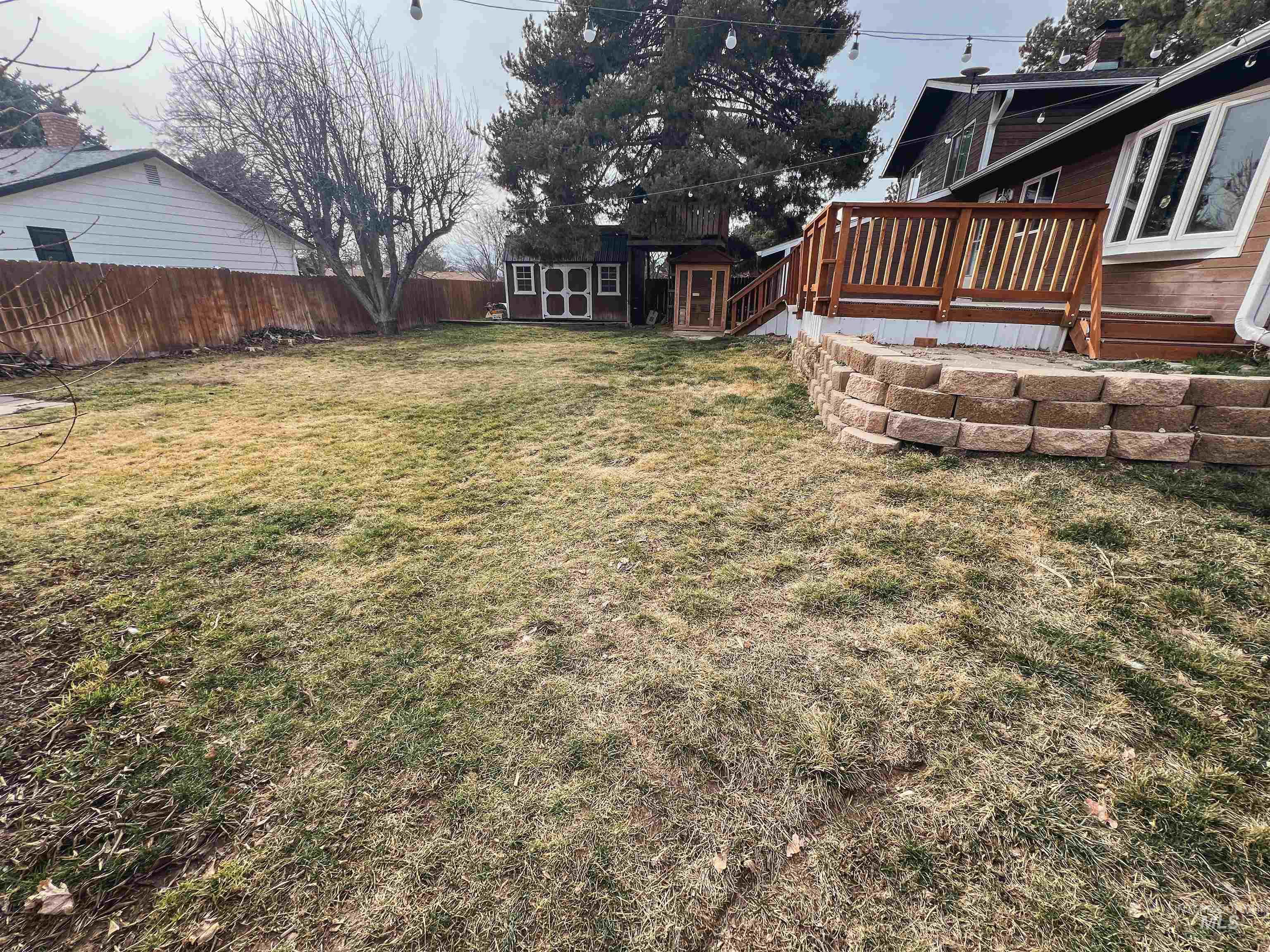 Fenced backyard with a wooden deck and a shed