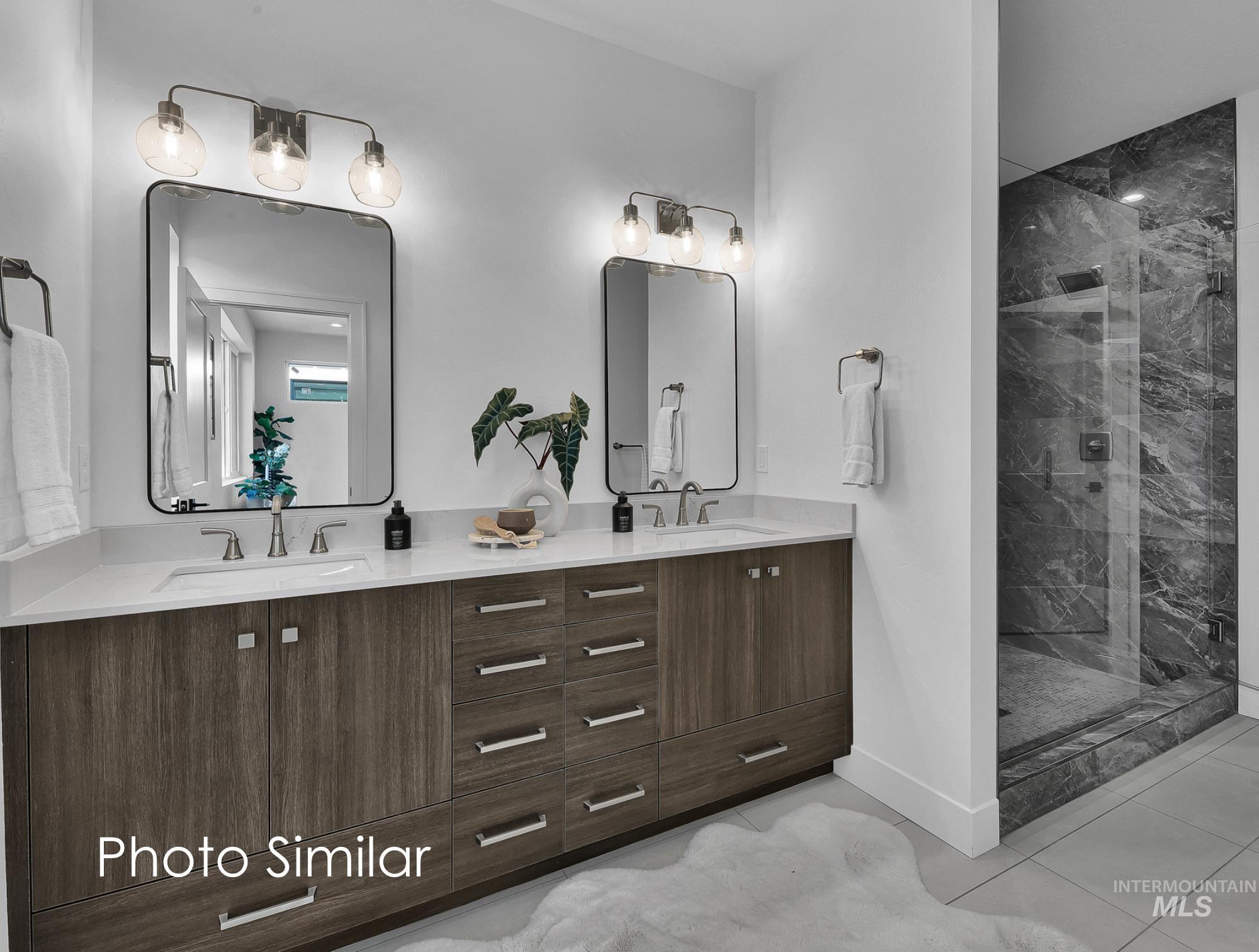 Bathroom featuring double vanity and a marble finish shower