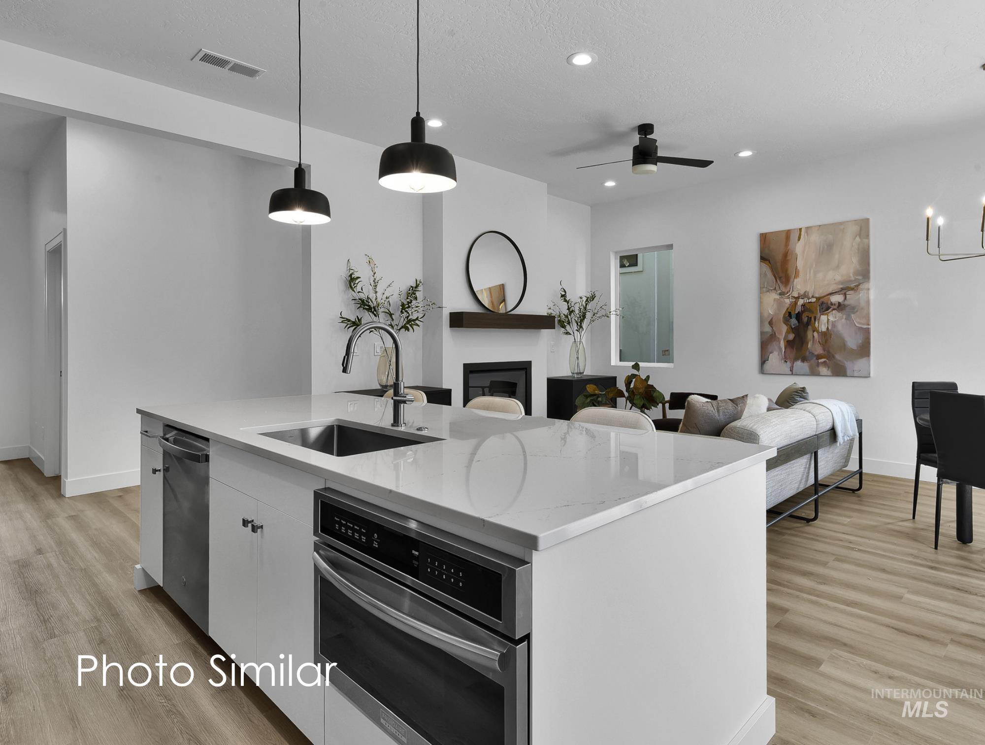 Kitchen with ceiling fan, light stone countertops, light wood finished floors, and open floor plan