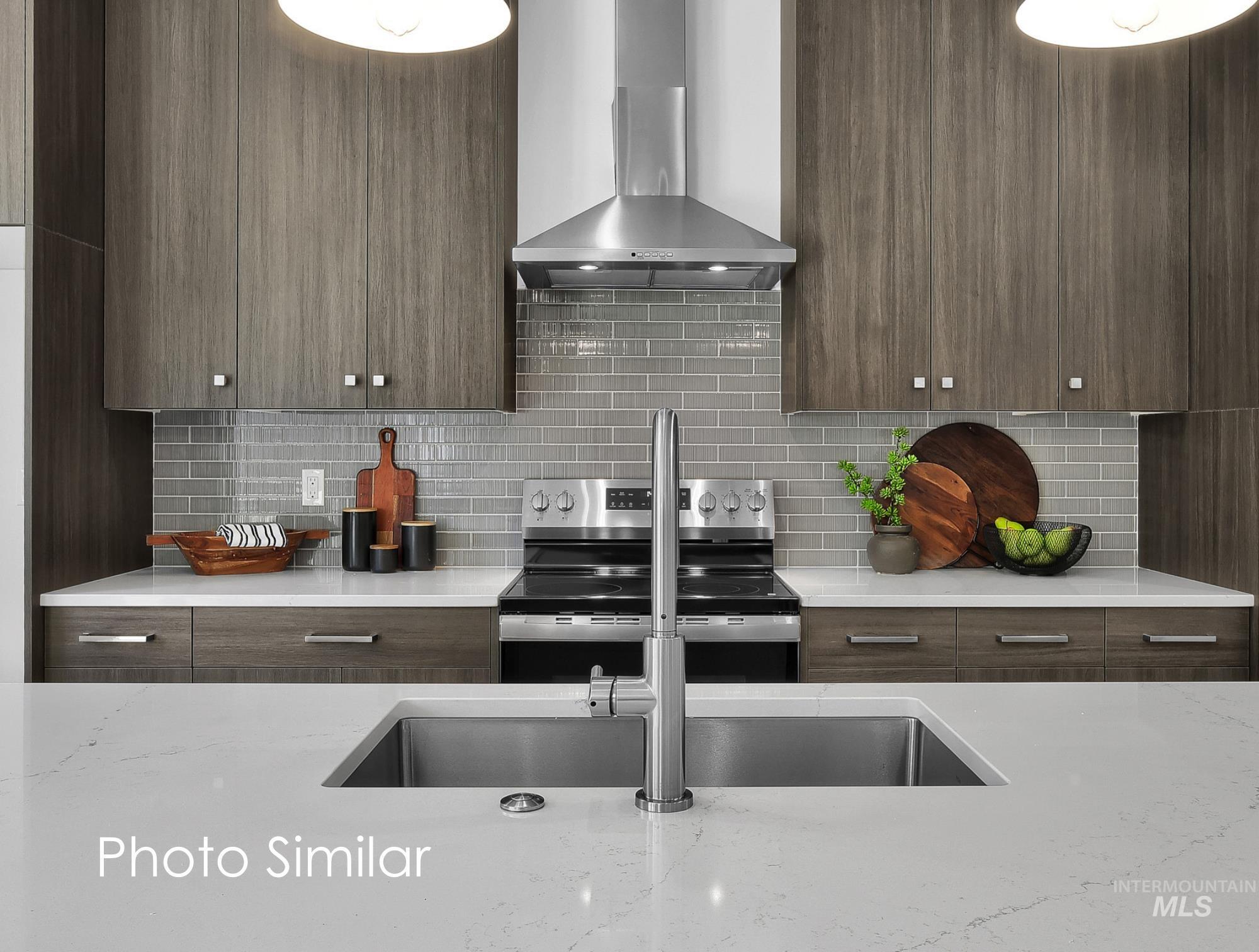 Kitchen with light stone countertops, modern cabinets, stainless steel electric stove, backsplash, and dark wood finish cabinetry