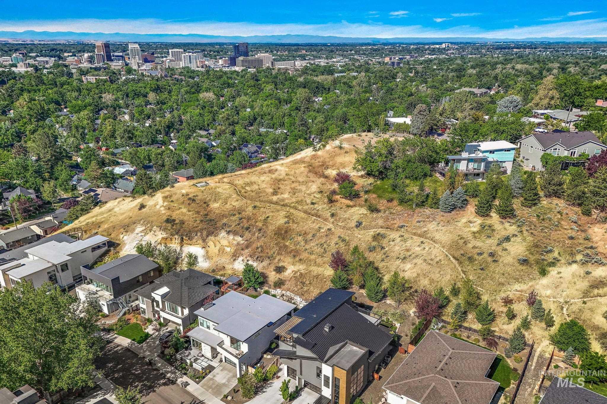 Elevated residential setting featuring a prominent hillside and distant cityscape