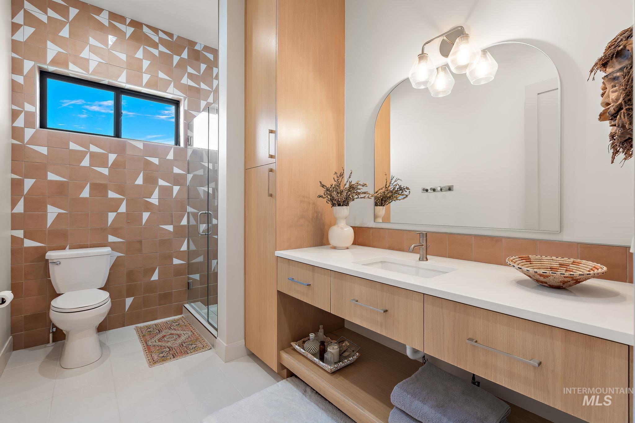 Contemporary bathroom featuring a light wood vanity with a white countertop and integrated sink