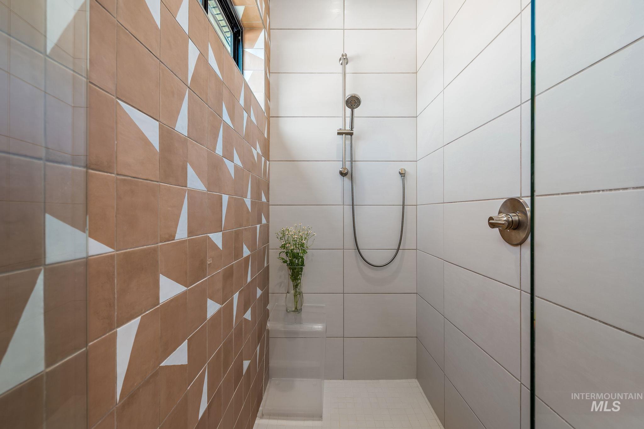 Walk-in shower featuring a glass enclosure with brushed nickel hardware