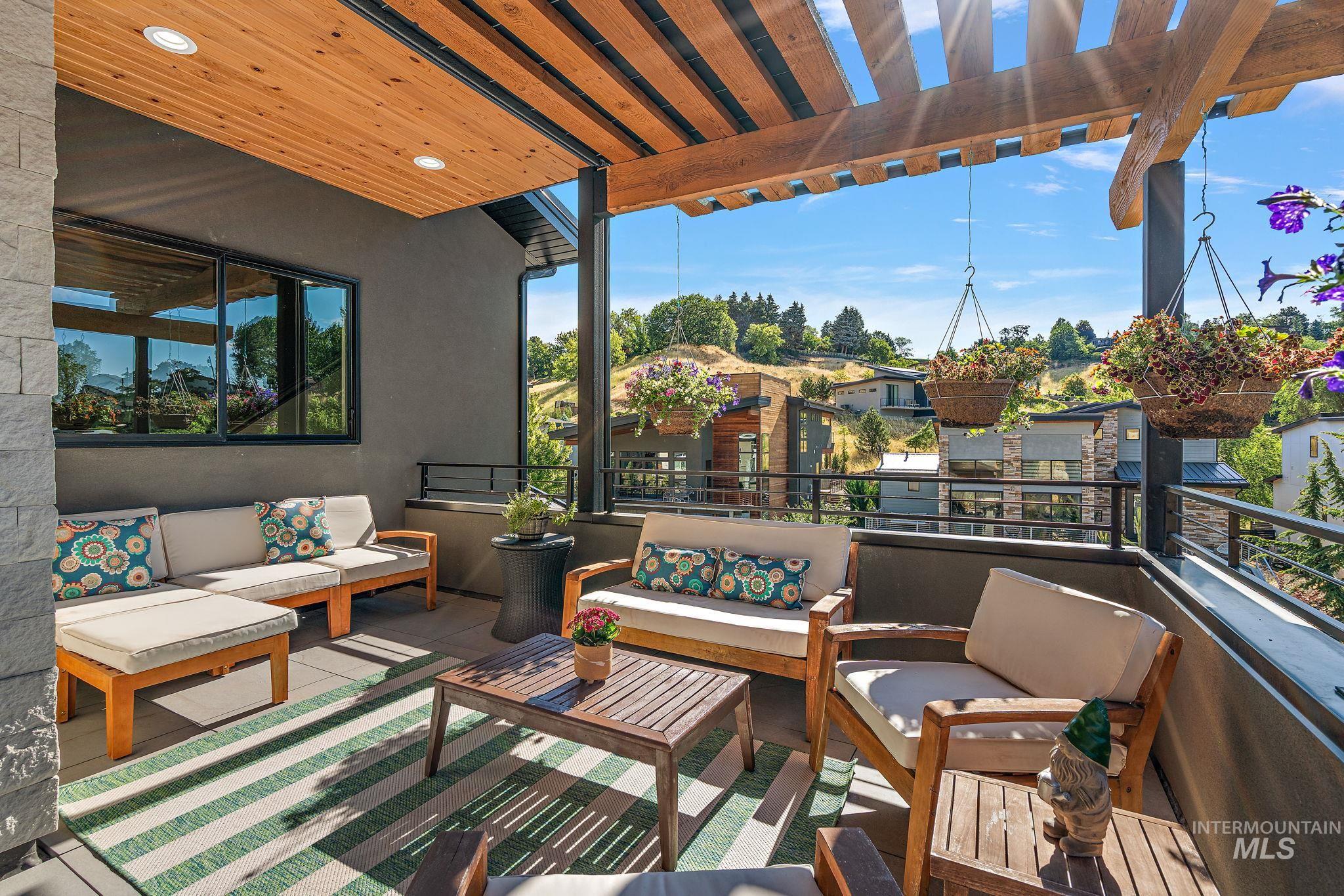 Covered balcony featuring a wood-slat ceiling, recessed lighting, and a stone accent wall
